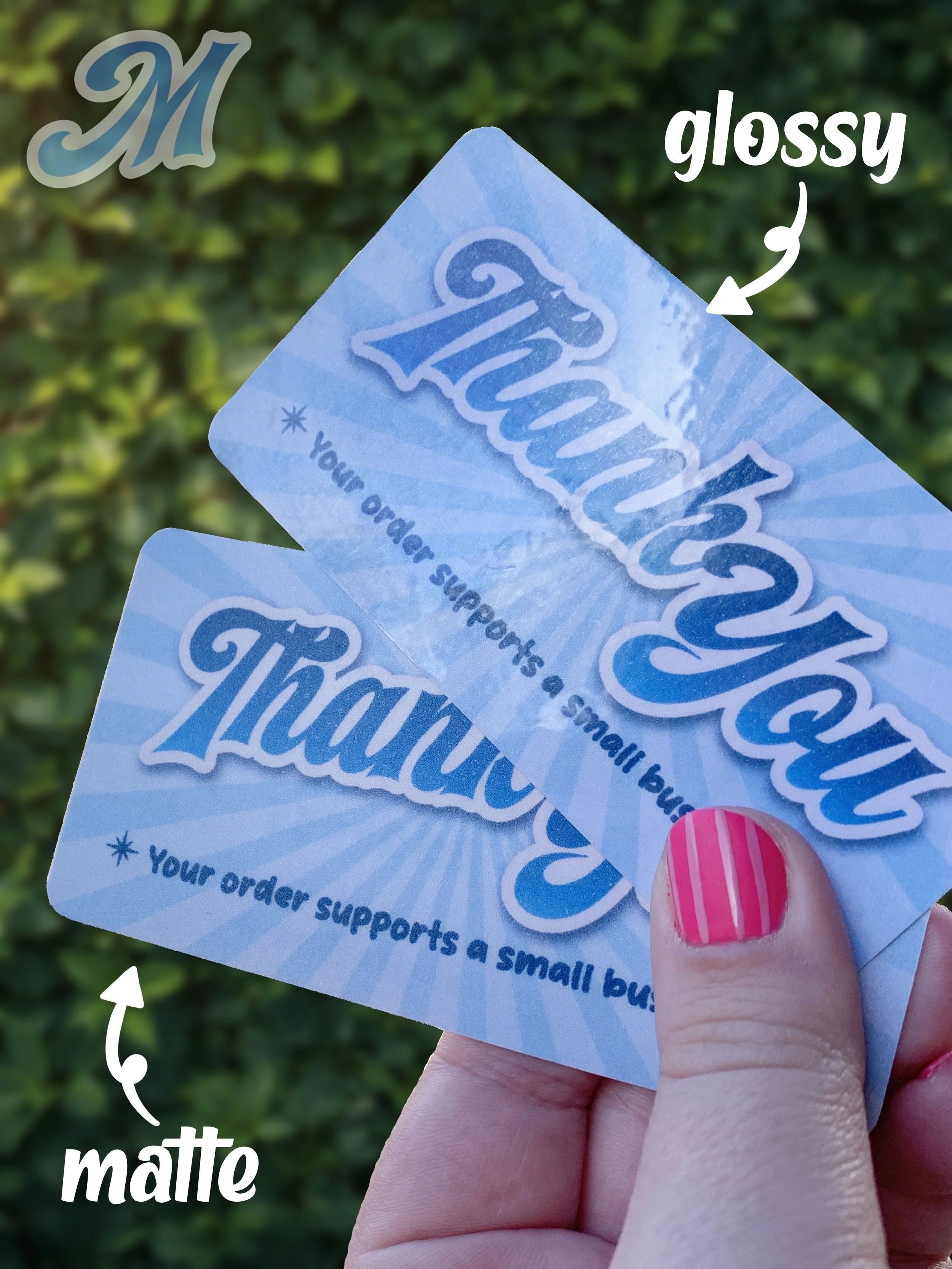 custom thank you inserts for small business packaging behind held by a hand in front of a bush showing matte and glossy laminate options