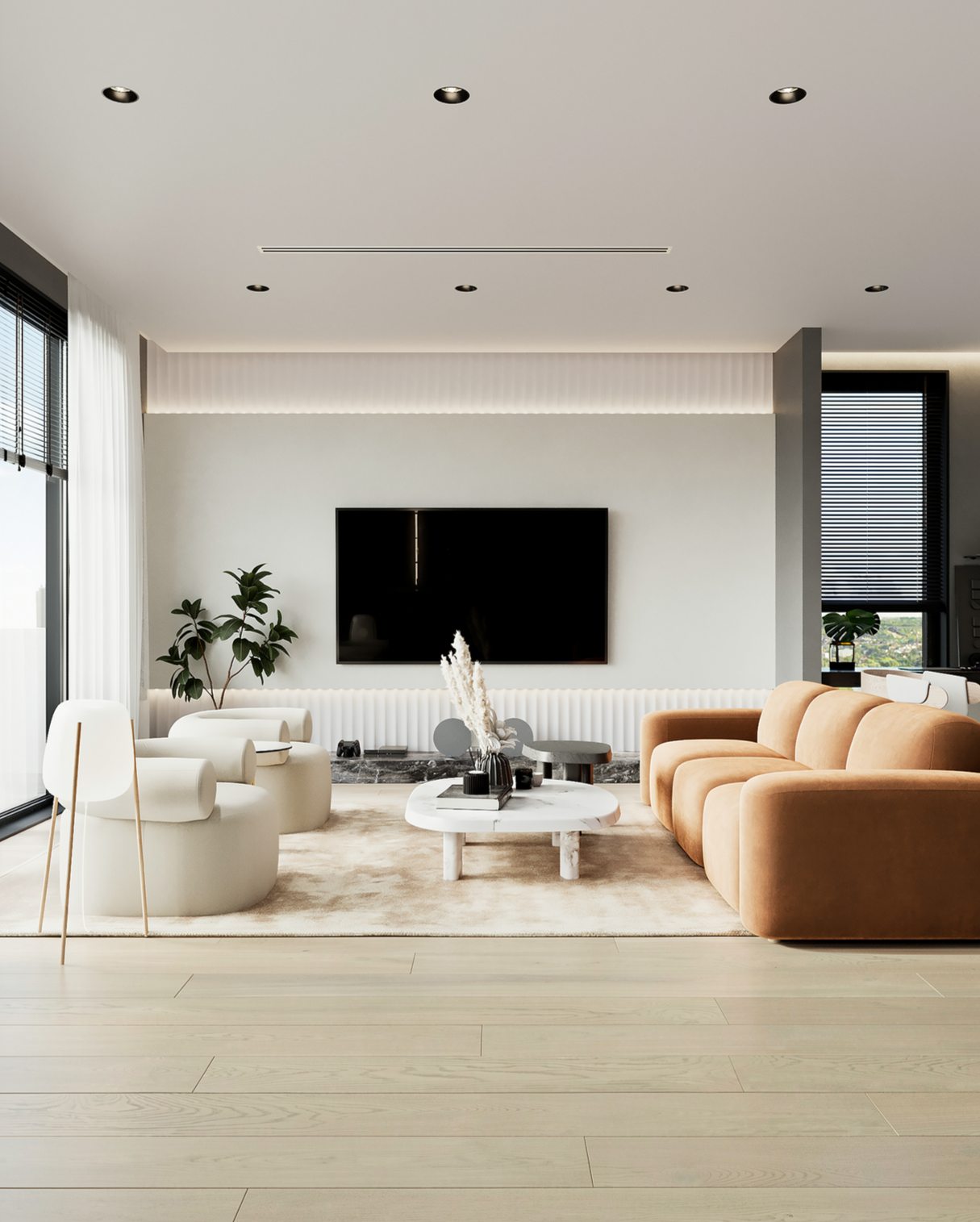 Modern living room with a beige sofa, white armchairs, a marble coffee table, a wall-mounted television, and large windows with blinds.