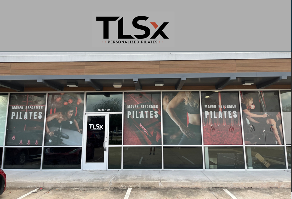 storefront window advertising Maven Reformer Pilates with images of women exercising and the TLSx logo at the top.