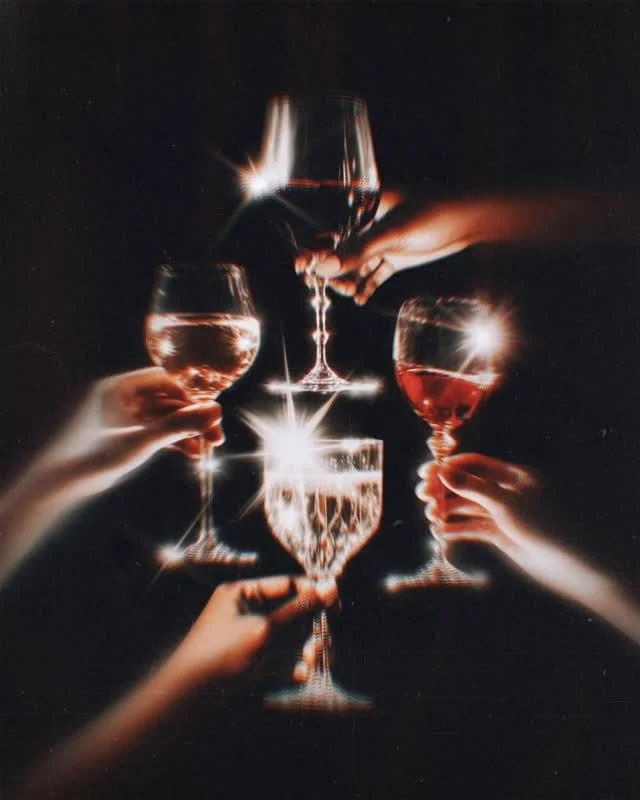 Five hands holding and toasting glasses filled with wine or champagne against a black background.