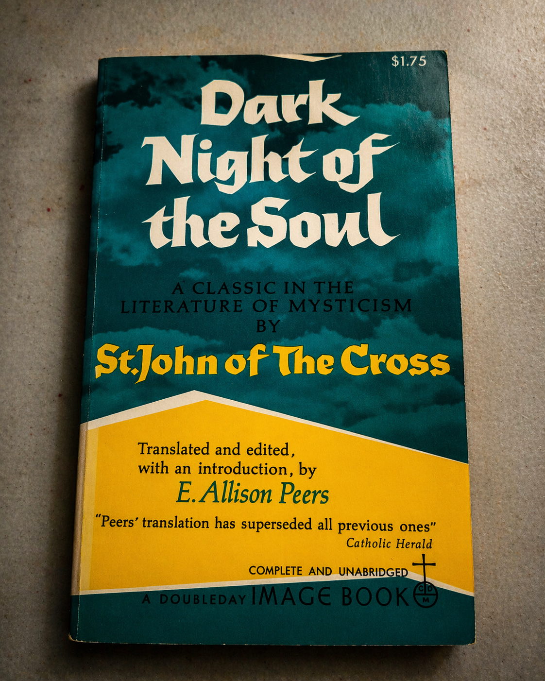 Book titled 'Dark Night of the Soul' by St. John of the Cross, translated and edited by E. Allison Peers, with a blue and yellow cover.