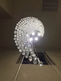 Rolling crystal globe chandelier install installed in a stairwell