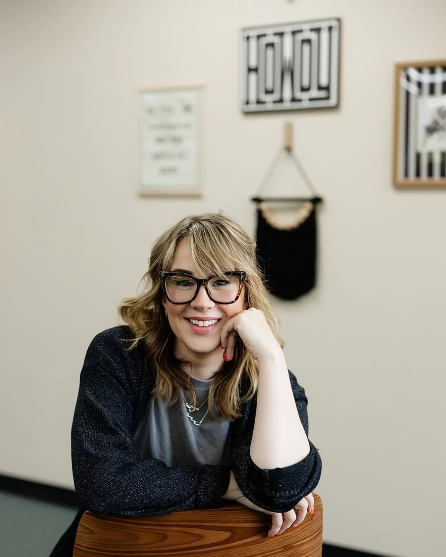 Blair Wilcox, owner and stylist at WAREHAUS Hair Studio in Manchester, Tennessee, leaning on a styling chair