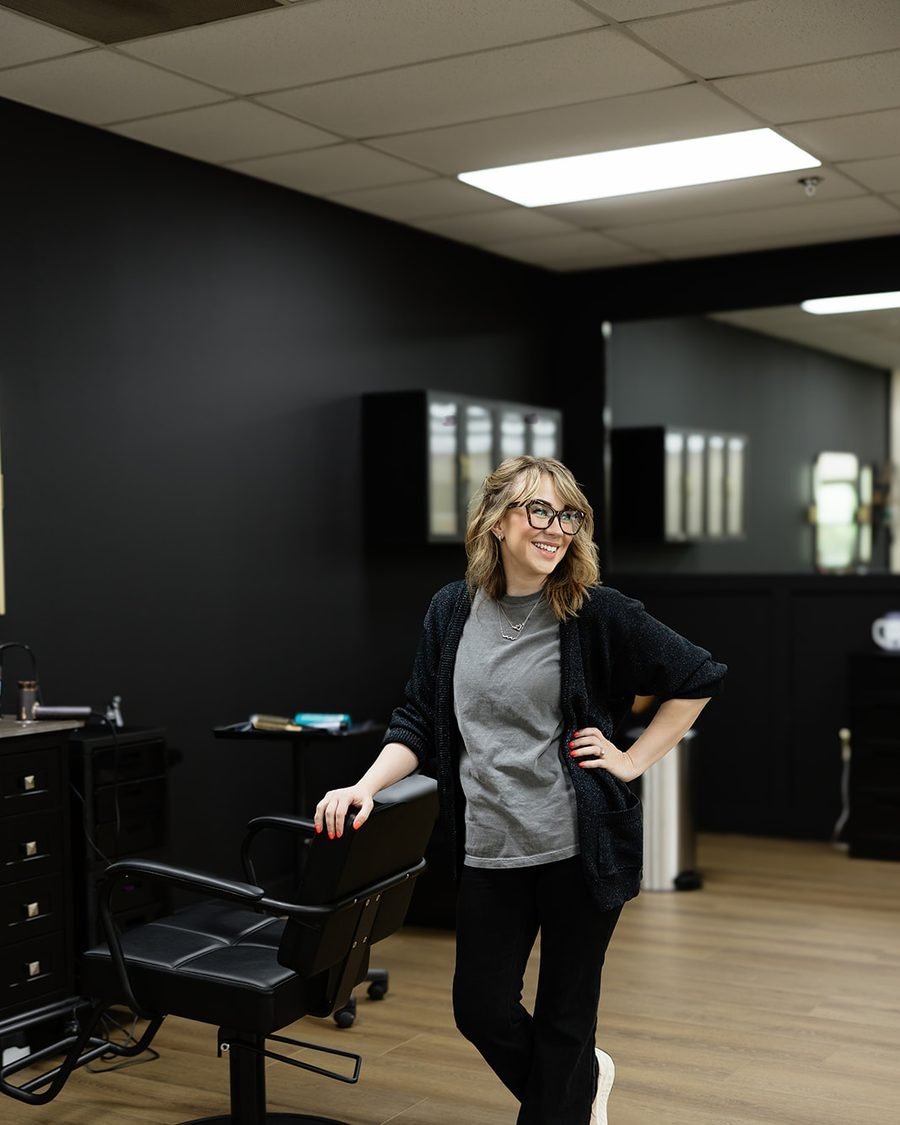 Blair Wilcox standing beside a styling chair at WAREHAUS Hair Studio in Manchester, Tennessee