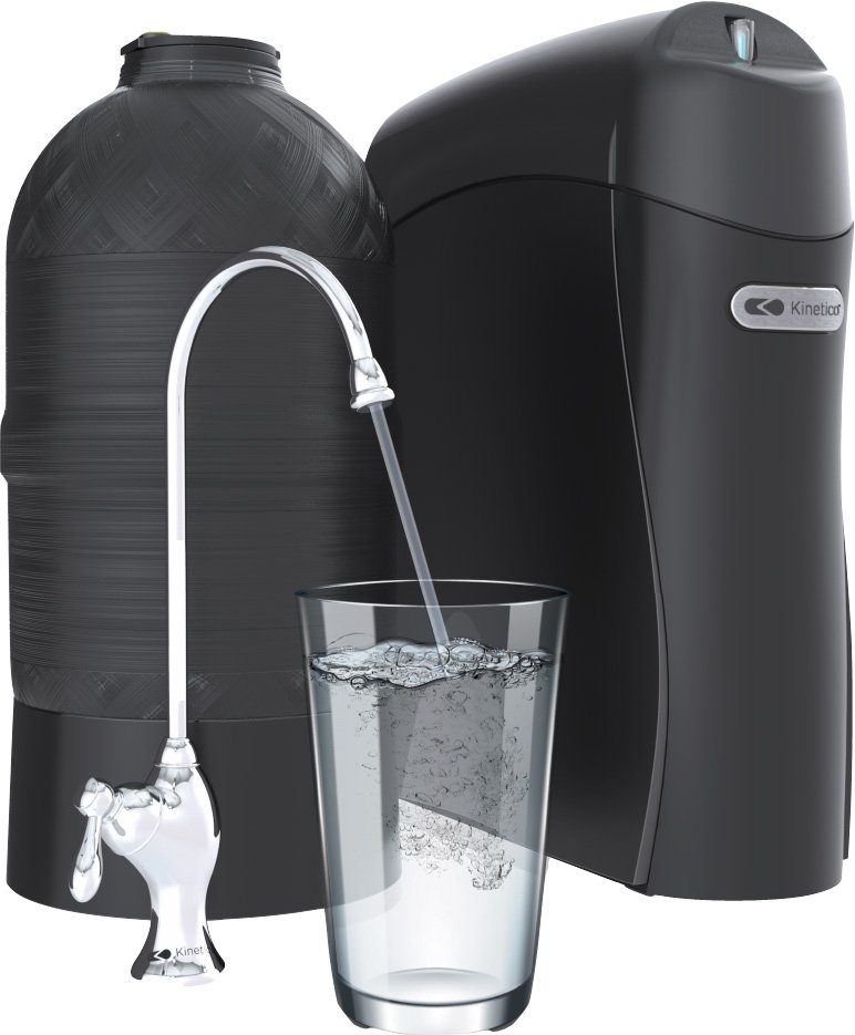 A water filtration system with a large black tank, a black and gray water purifier, and a glass of water being filled from a faucet attached to the tank.