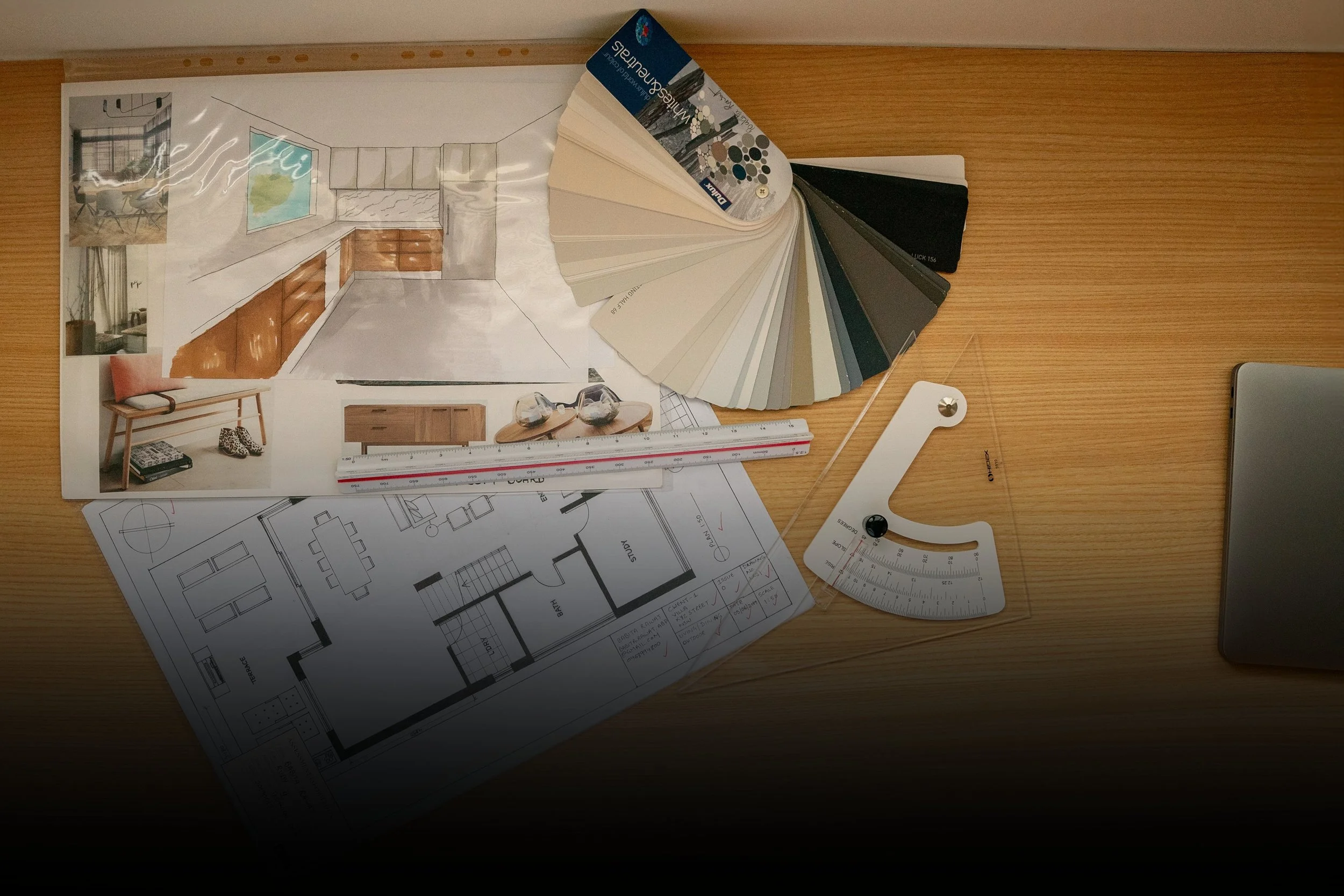 Interior design workspace with color swatches, architectural drawings, and mood board for a home renovation project.