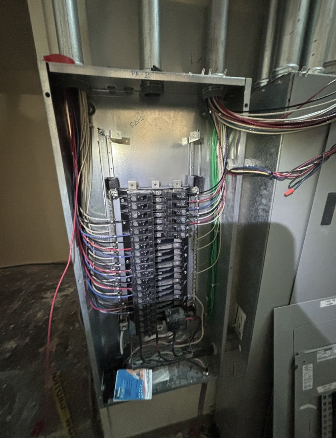 An electrical breaker panel with multiple wires connected to circuit breakers.