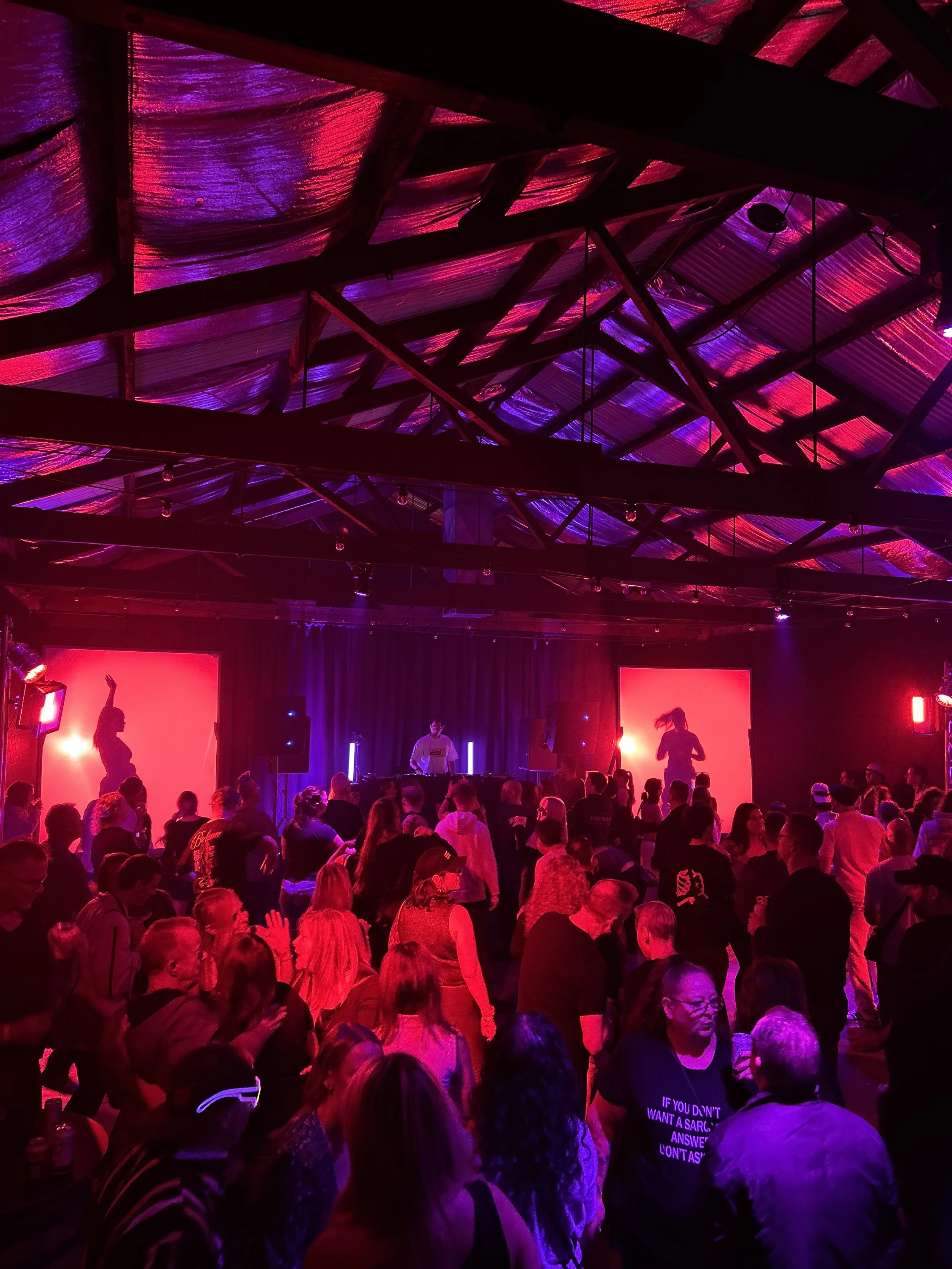 Crowd dancing under pink and red lights at a party at Warehouse 16