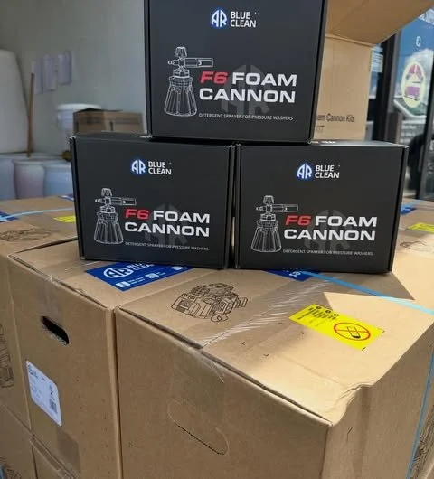 Three boxes labeled 'Blue Clean F6 Foam Cannon' placed on a large cardboard box in a warehouse or store.