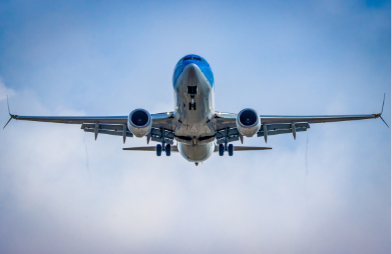 A commercial airplane flying in the sky, viewed from below.