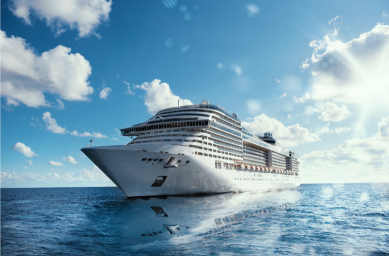 Large cruise ship sailing on blue ocean under partly cloudy sky