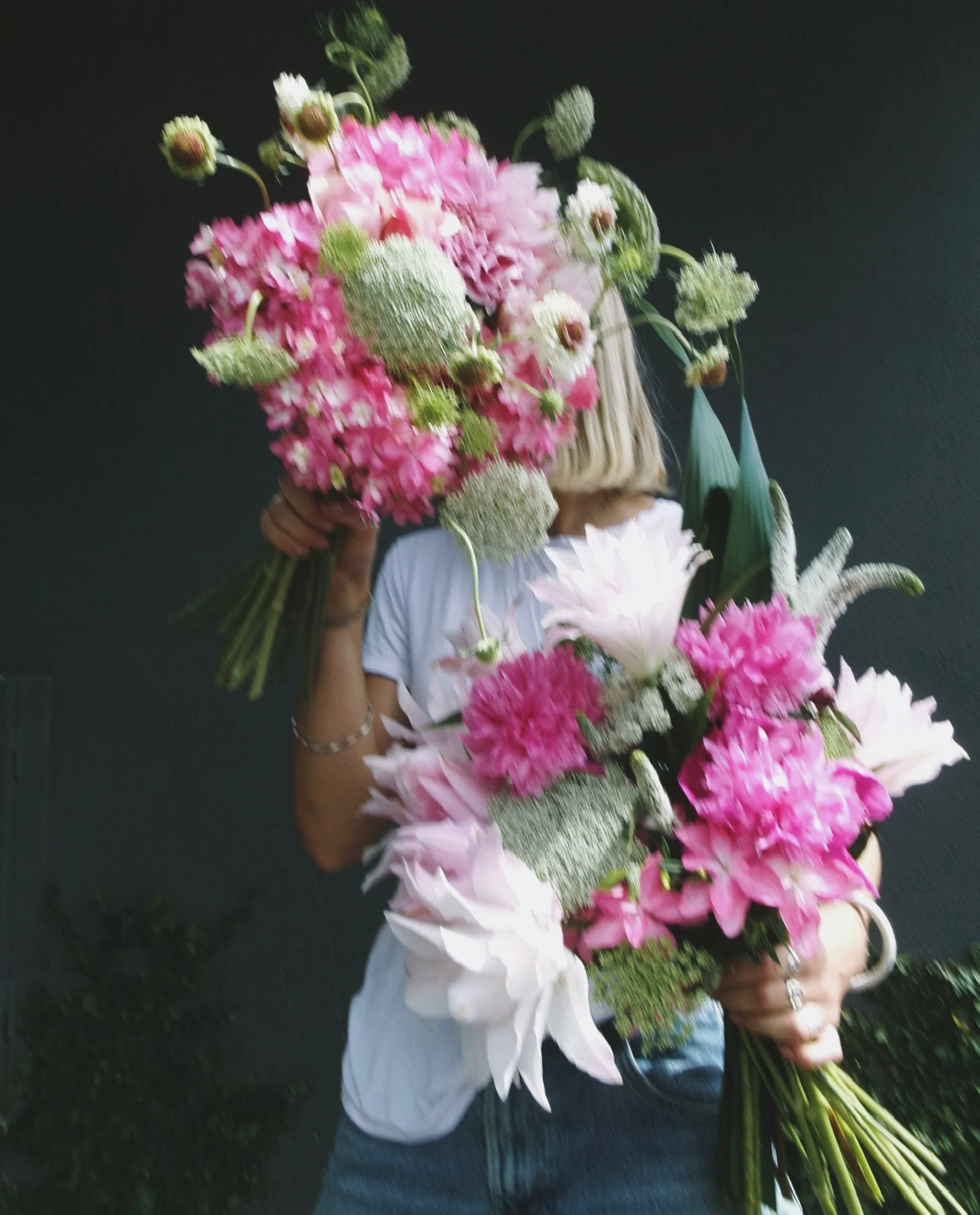 Dazzling and abundant bouquets of pink, white, and green flowers against a dark background.