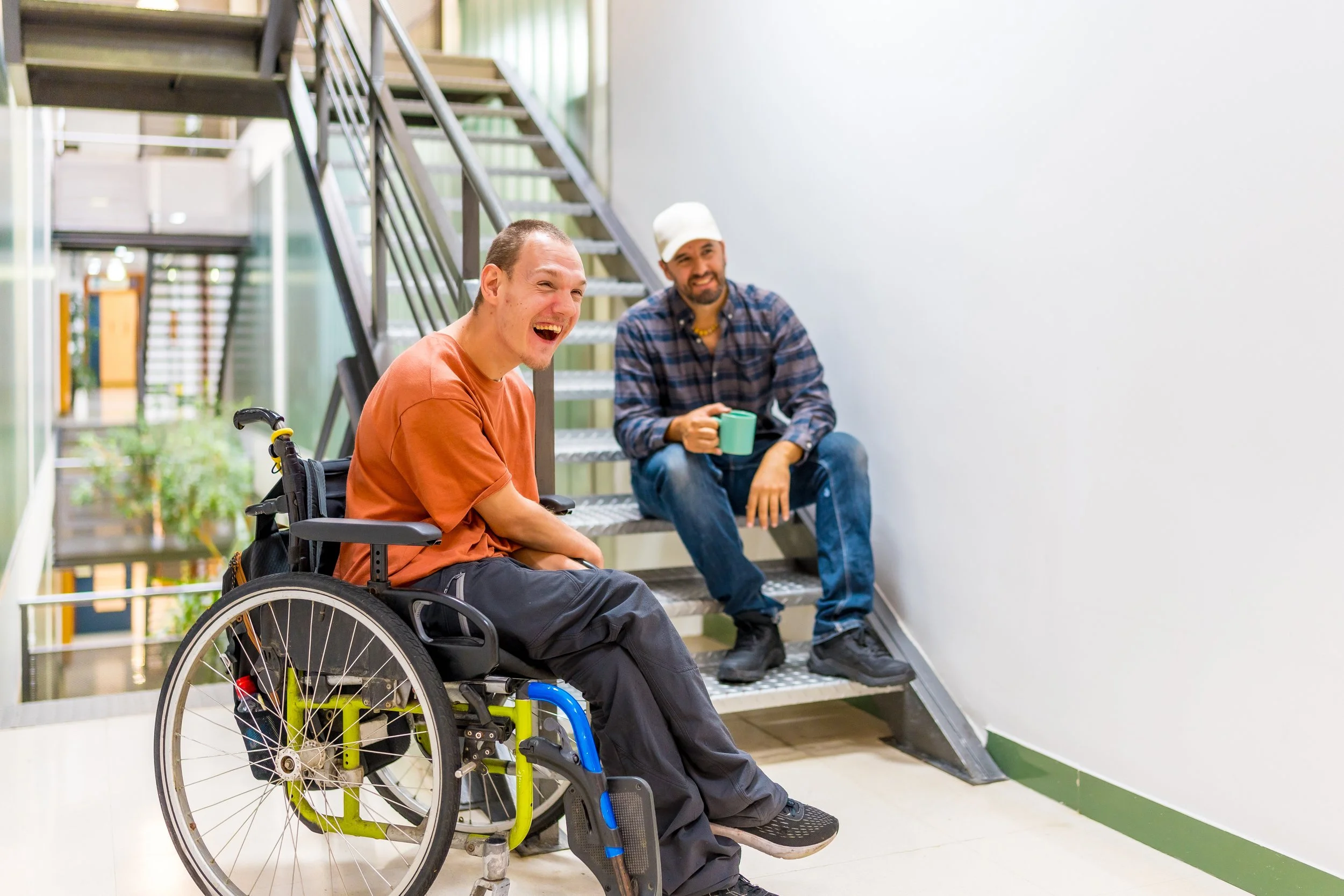 Chair User in Stairwell with Colleague