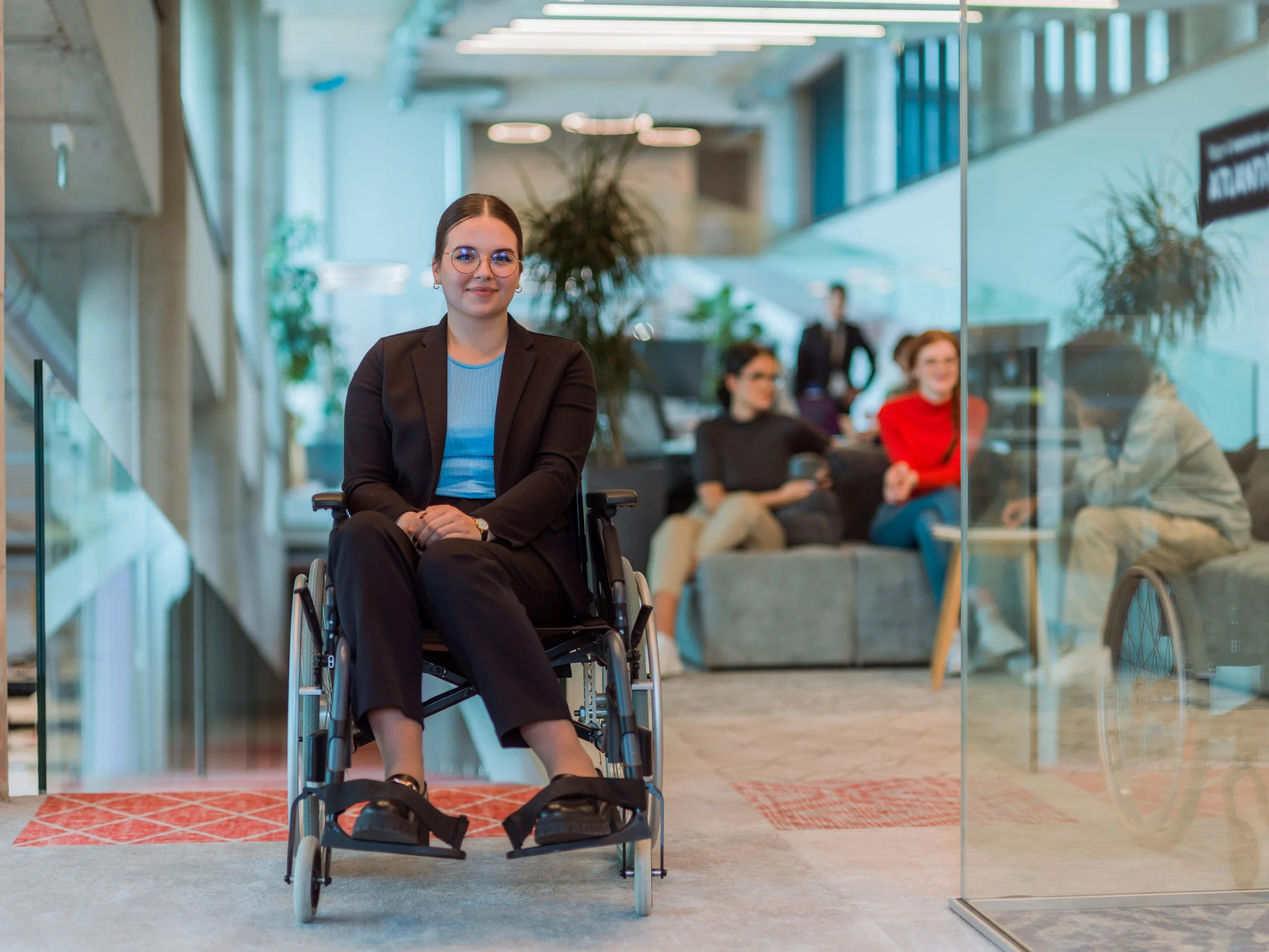 Female chair user in modern office, smiling at camera.