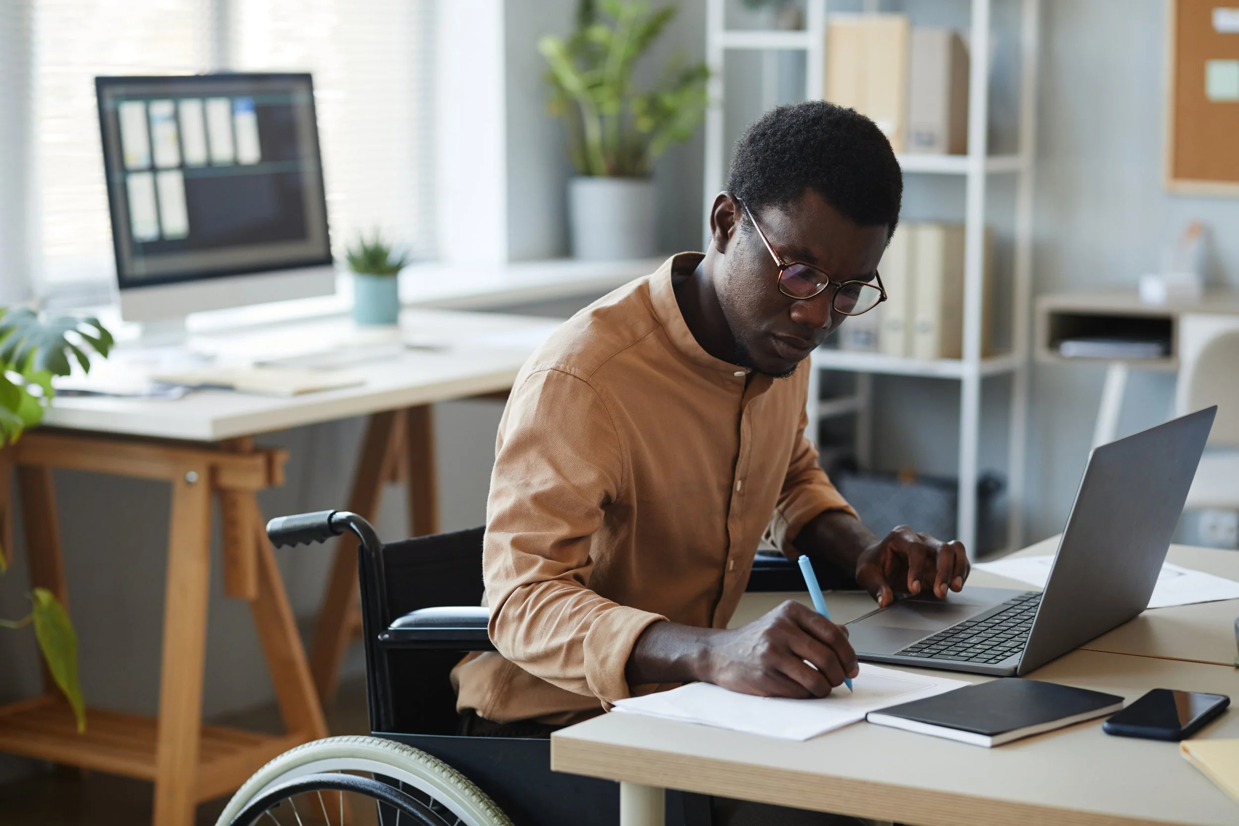 Chair User at desk with laptop and paper
