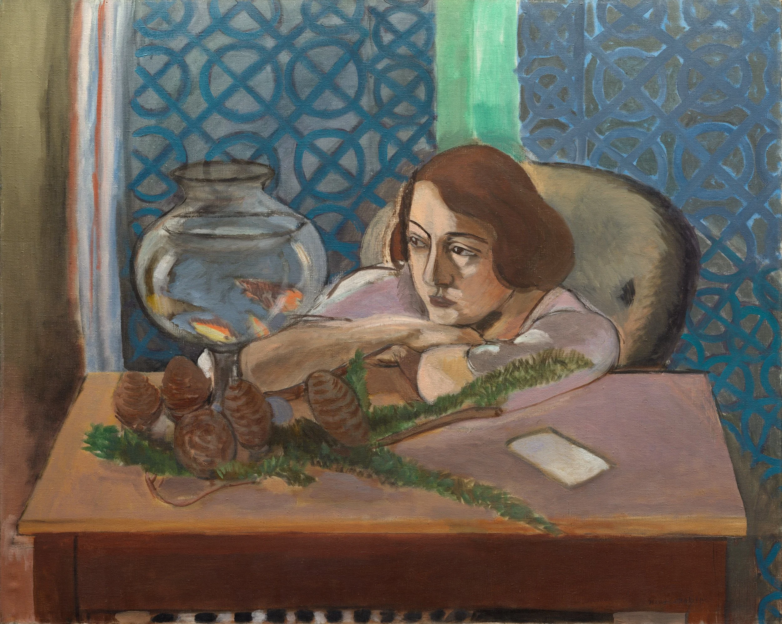 A woman with brown hair rests her head on her arm at a table, looking contemplative. On the table, there is a fishbowl with fish and a cluster of pinecones and greenery. The background features a textured blue curtain and a window with a green shade.