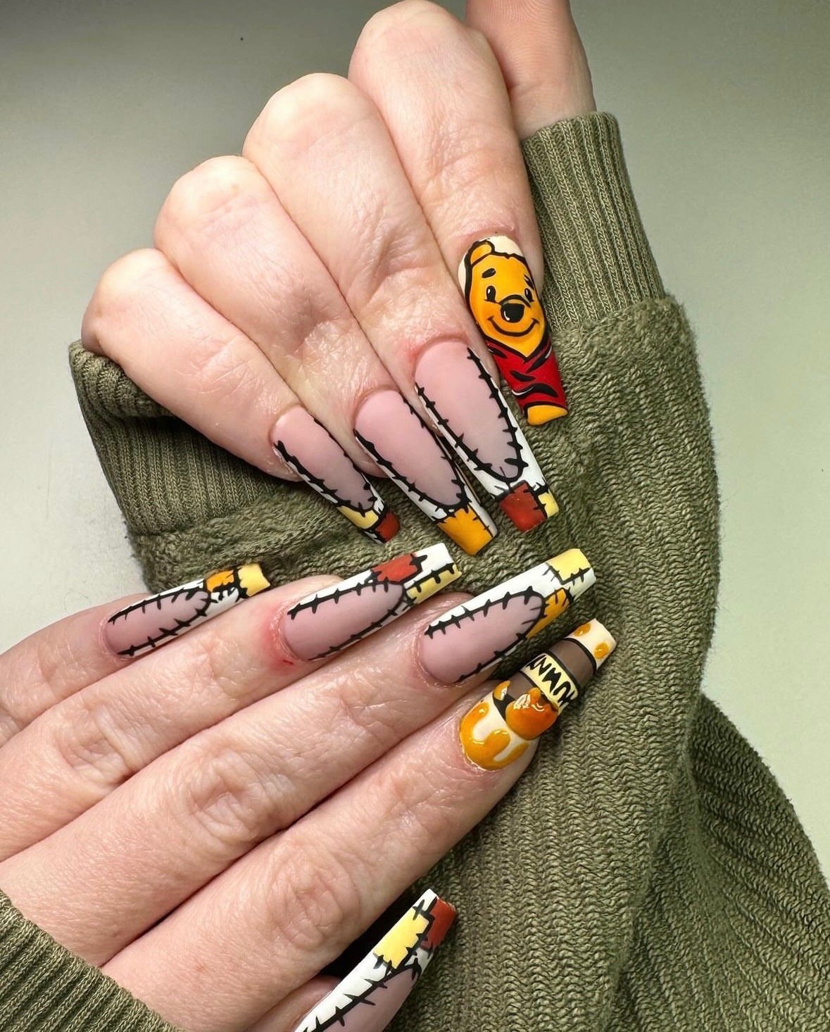 Hand painted with Winnie the Pooh cartoon Halloween-themed nail art including stitches, pumpkins.
