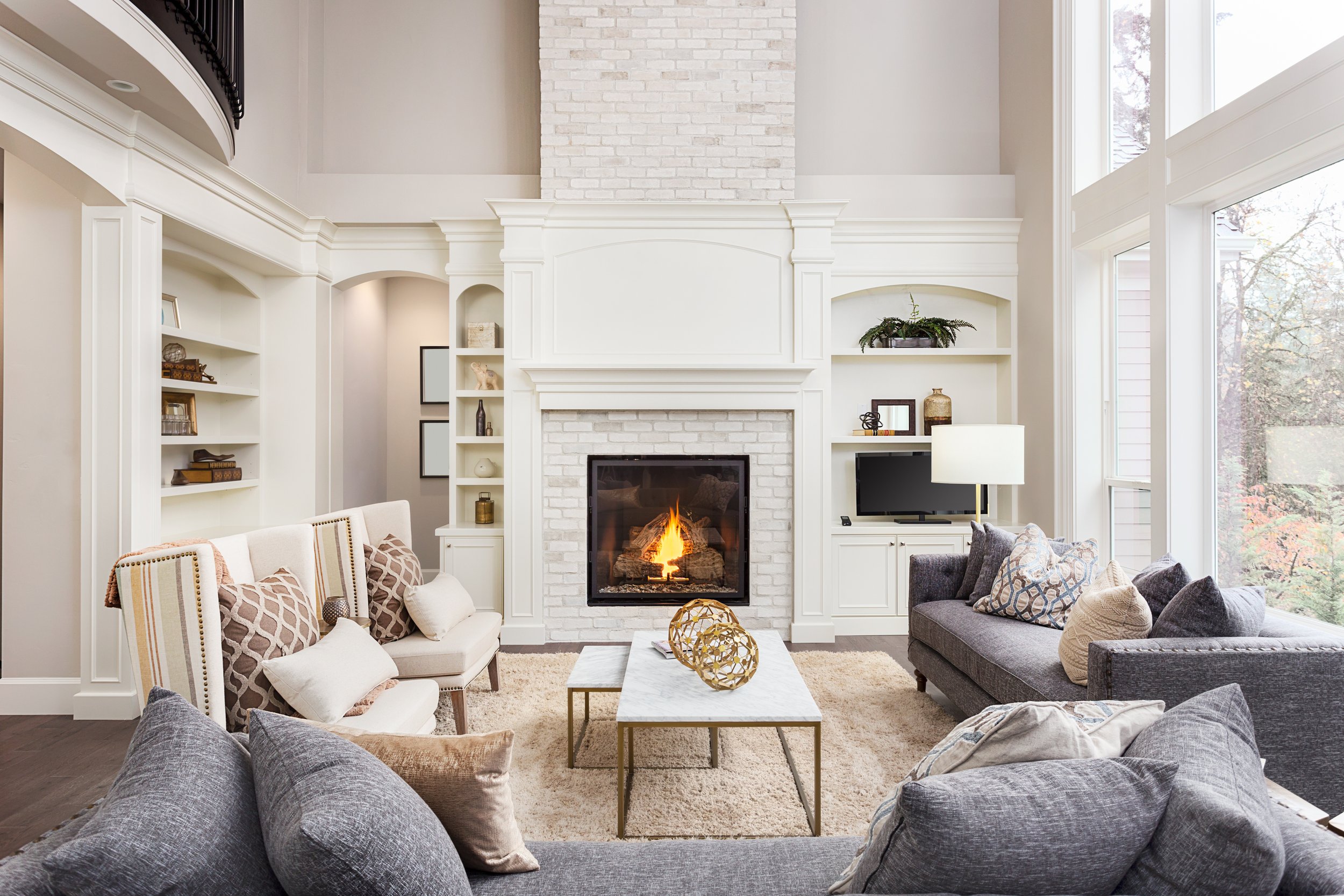 Bright living room with cozy, lit white brick fireplace