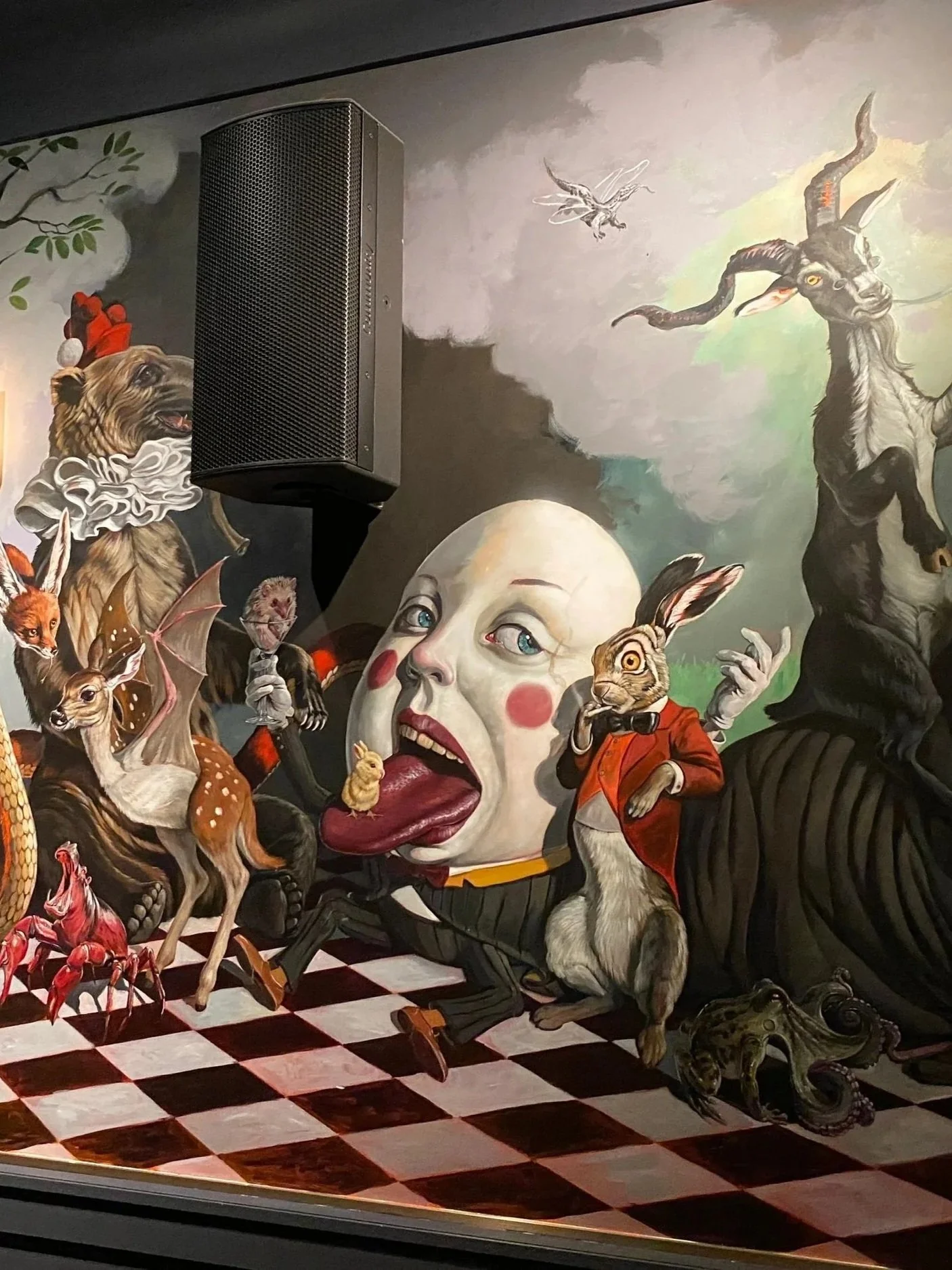 A mural featuring various animals with human-like features, including a dog wearing a Santa hat, a fox, a bat, a rabbit, a wolf, and a lion, set against a colorful cloudy sky and a checkered floor.