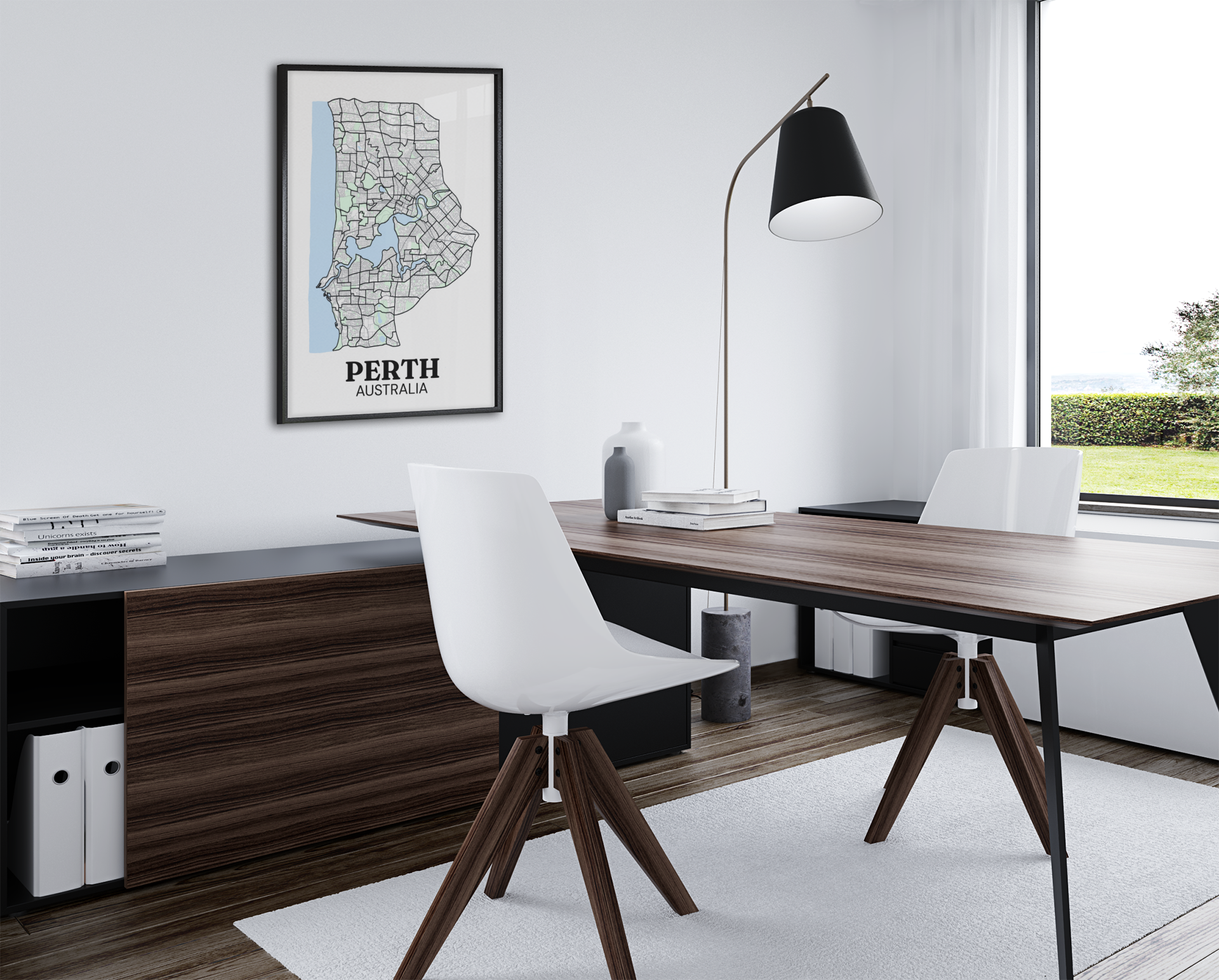 Black-framed colour street map print of Perth, Australia hung above a dark wood office desk with a black arc floor lamp.