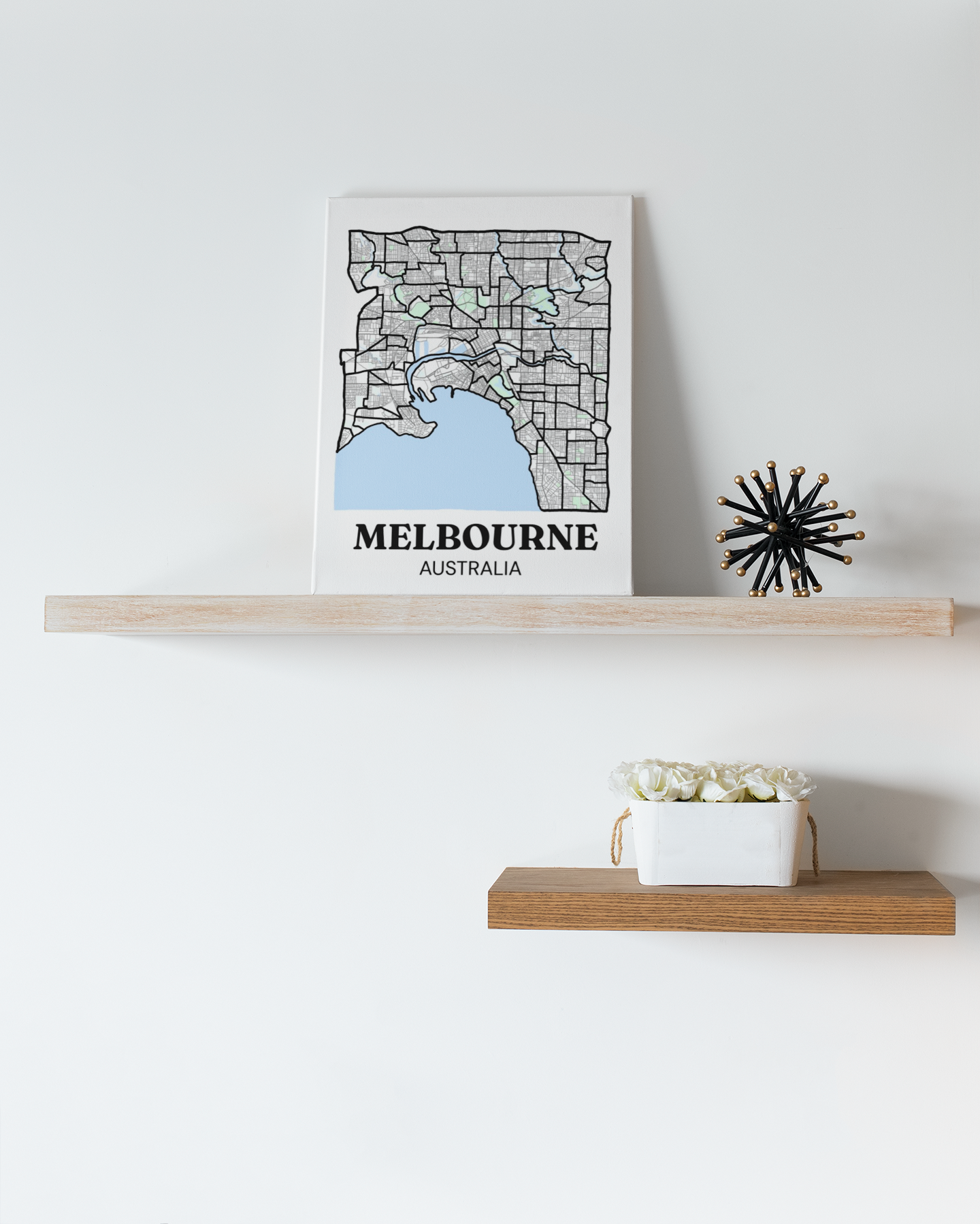 Melbourne inner suburb map canvas displayed on a floating shelf beside a decorative starburst ornament