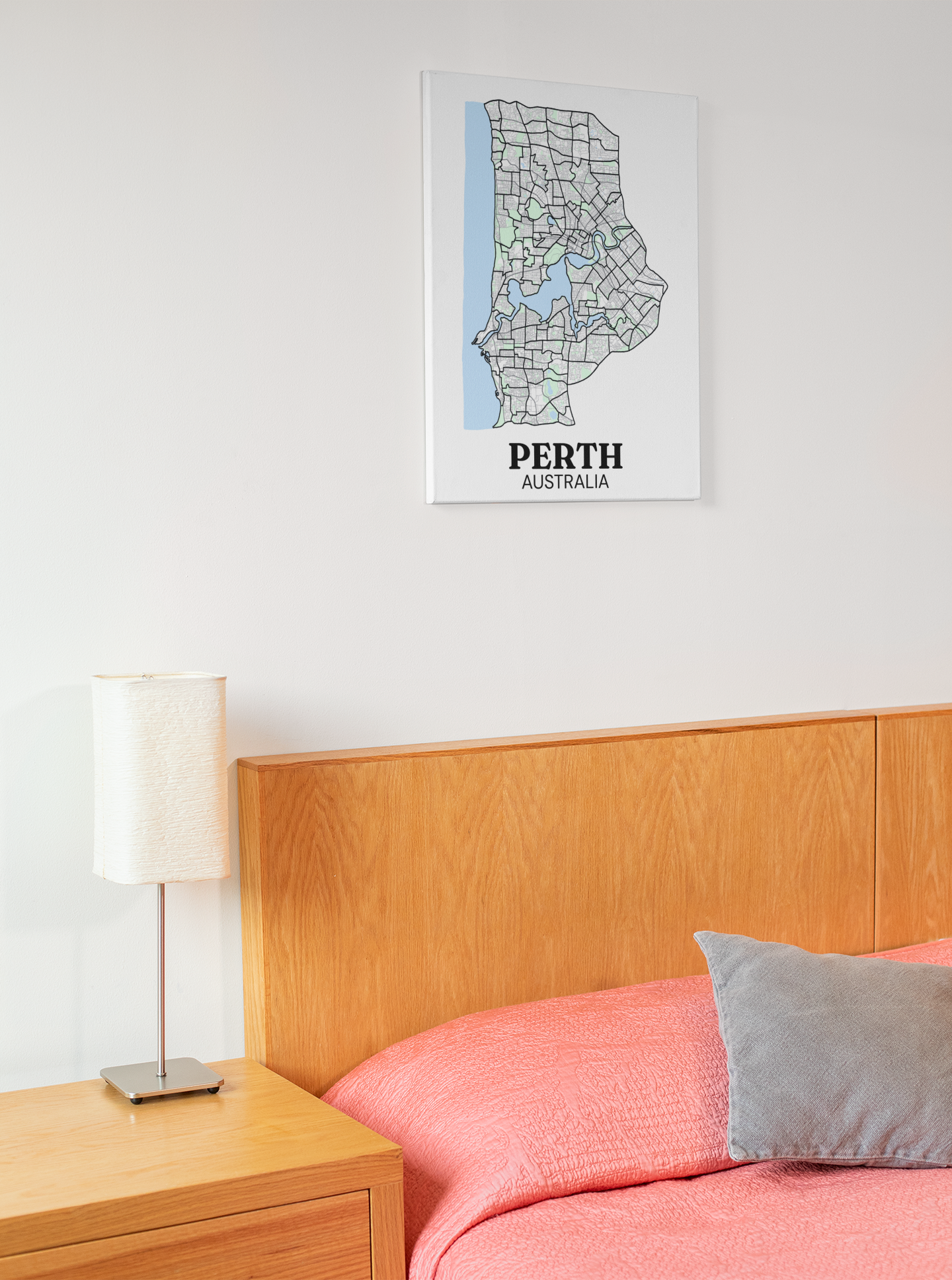 Colour street map canvas print of Perth, Australia hung above a wooden bed headboard with pink bedding and a grey cushion.