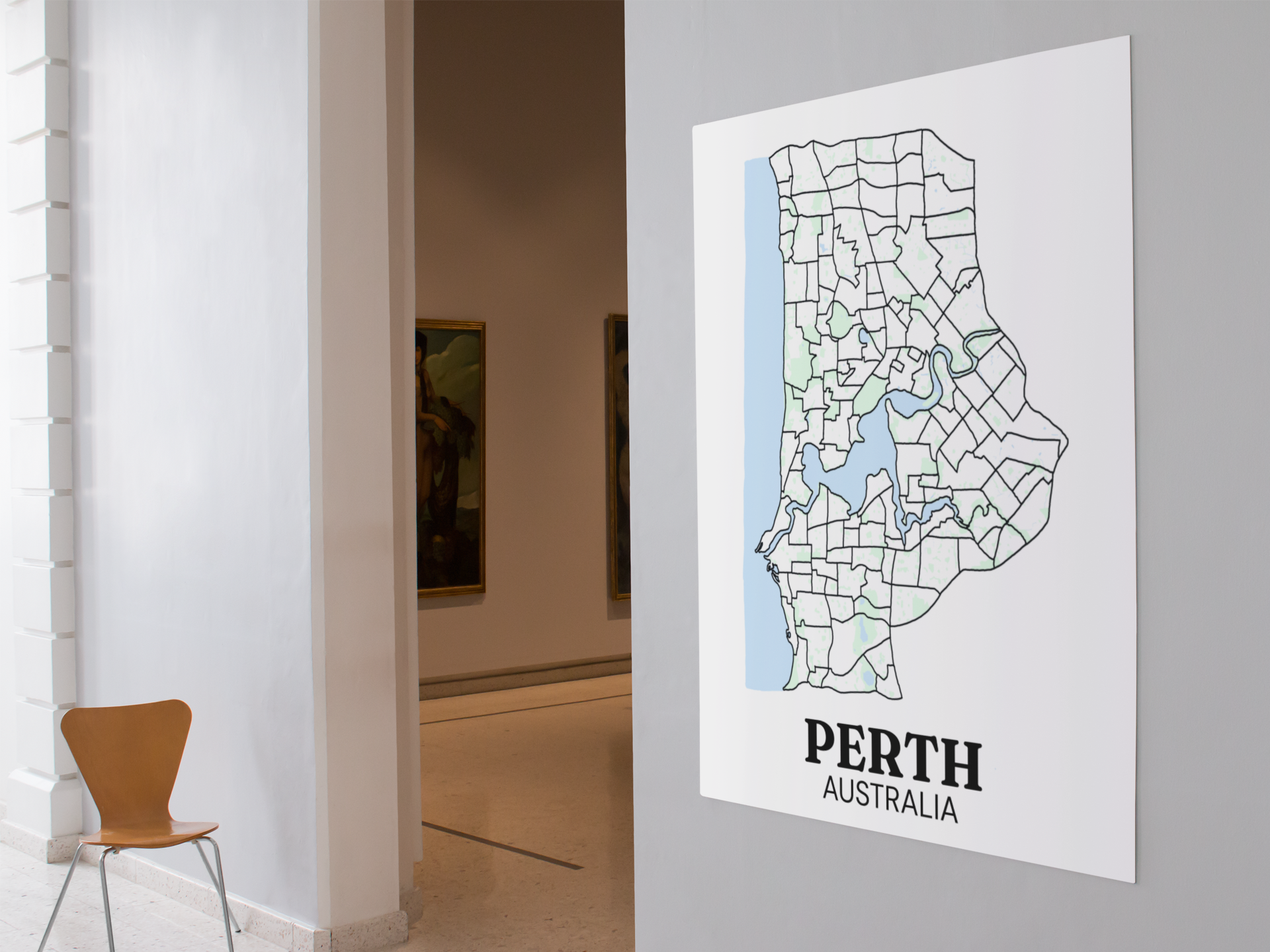 Unframed suburb boundary map poster of Perth, Australia displayed on a gallery wall beside an open doorway with framed paintings visible.