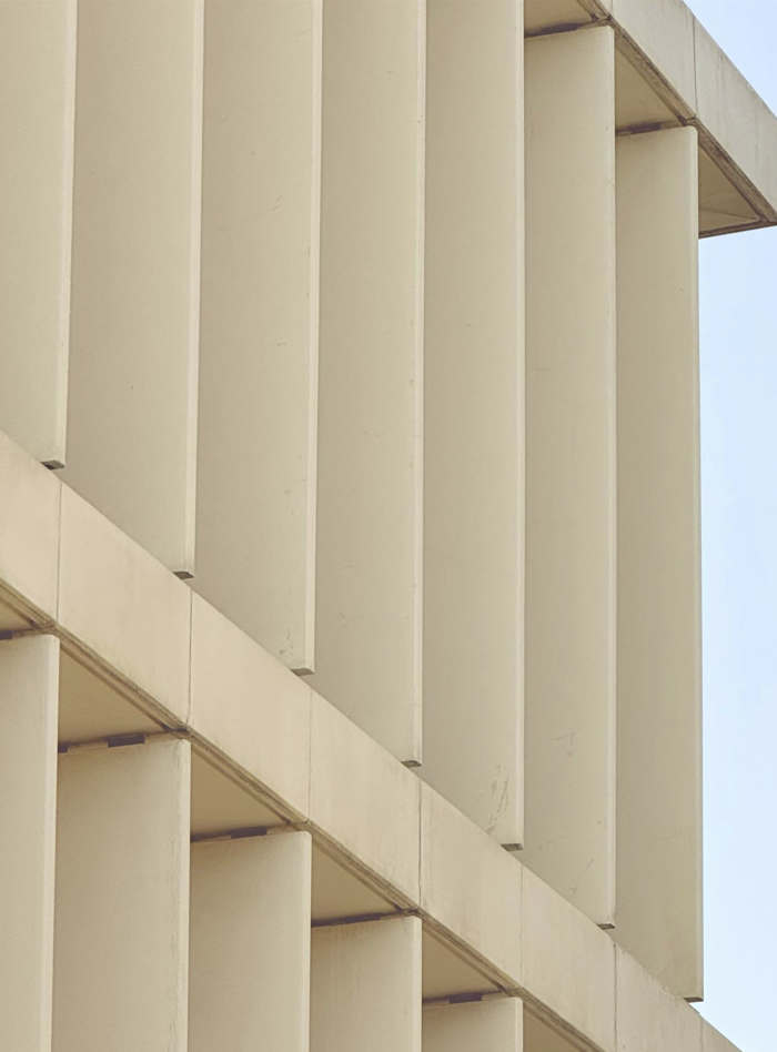Close-up of a modern building's facade with vertical white concrete panels.