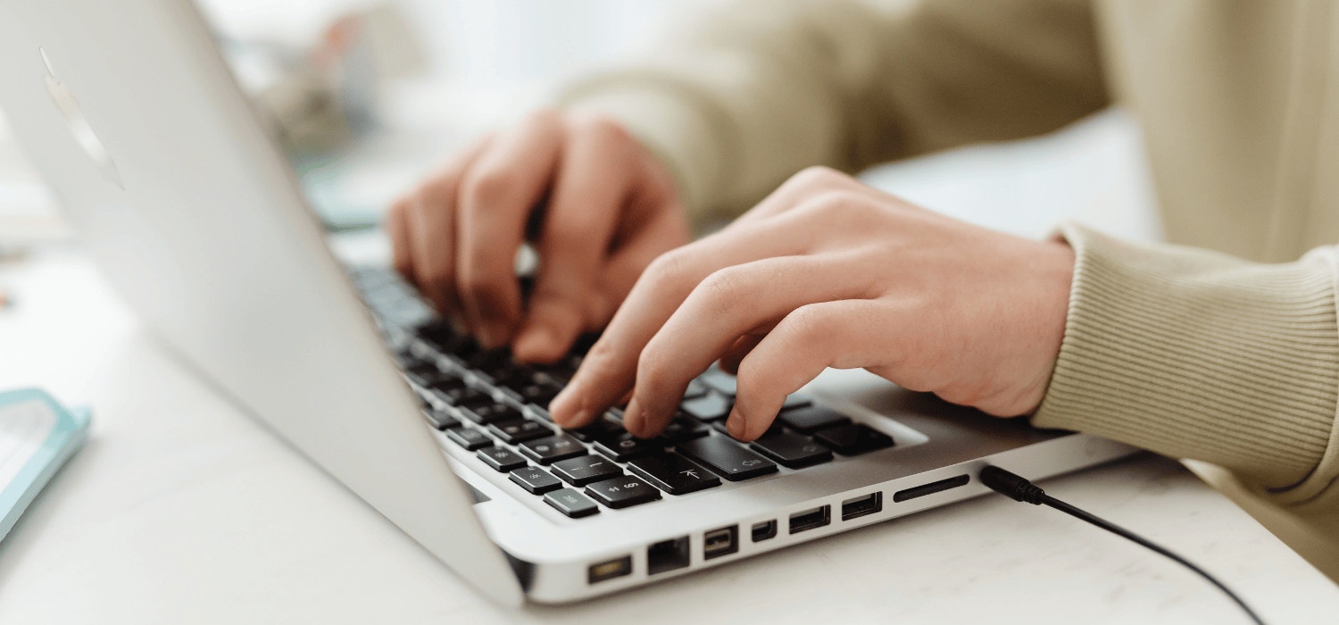 Hands typing a blog on a laptop