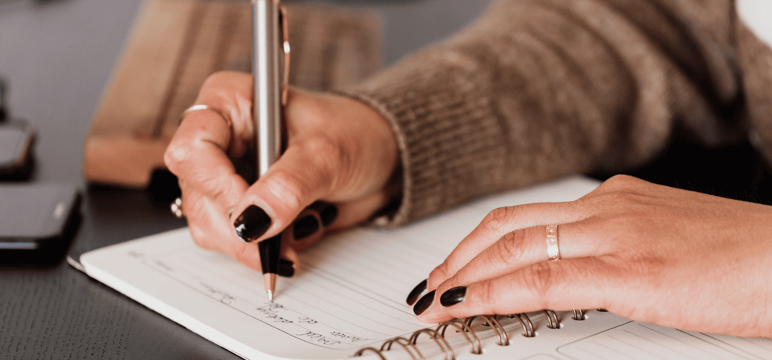 Hands writing in a notebook