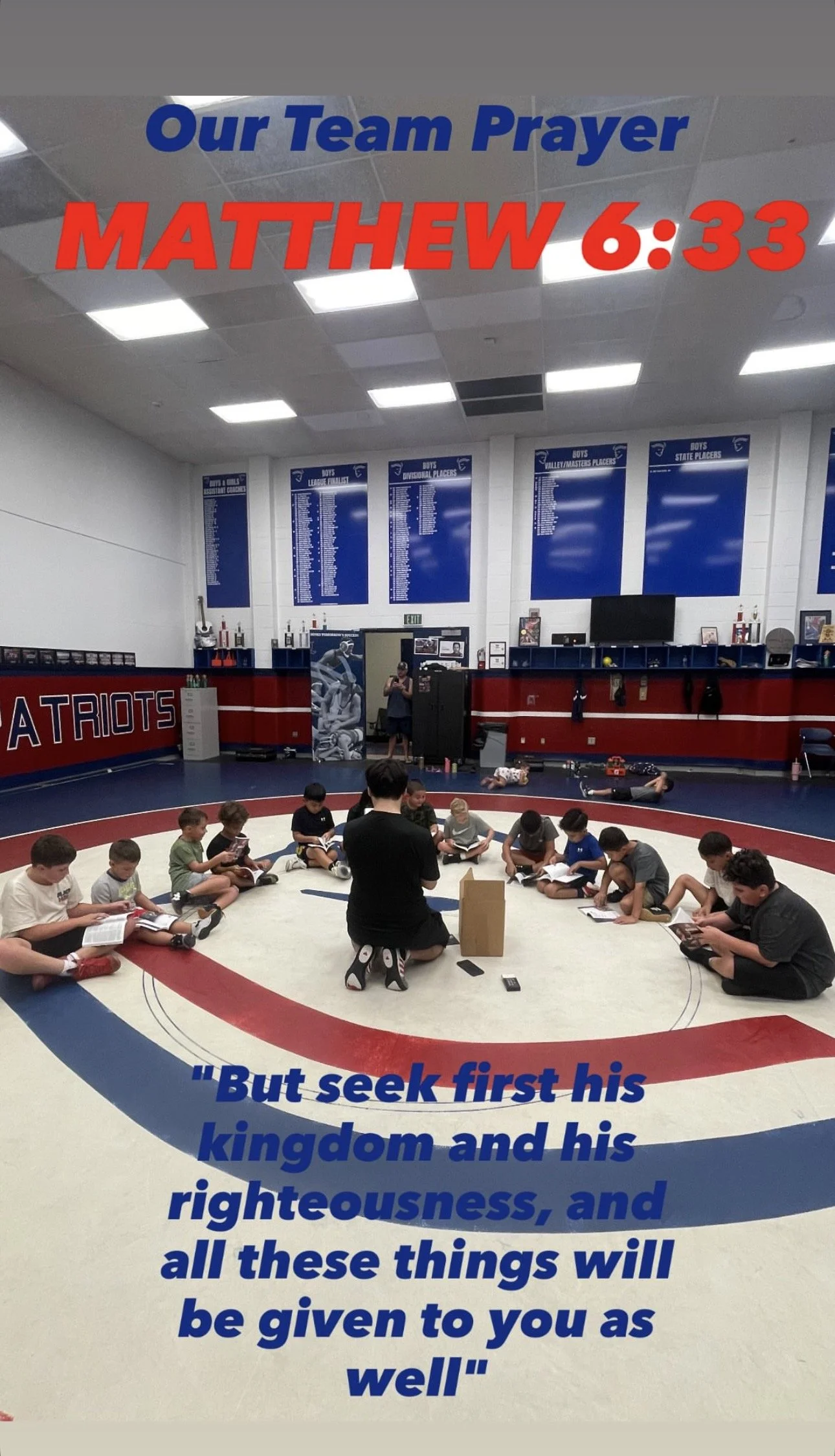 A group of children sitting on a wrestling mat in a gym, listening to a man kneeling in front of them, with prayer posters on the wall behind. The image has overlaid text about a team prayer and a Bible verse.