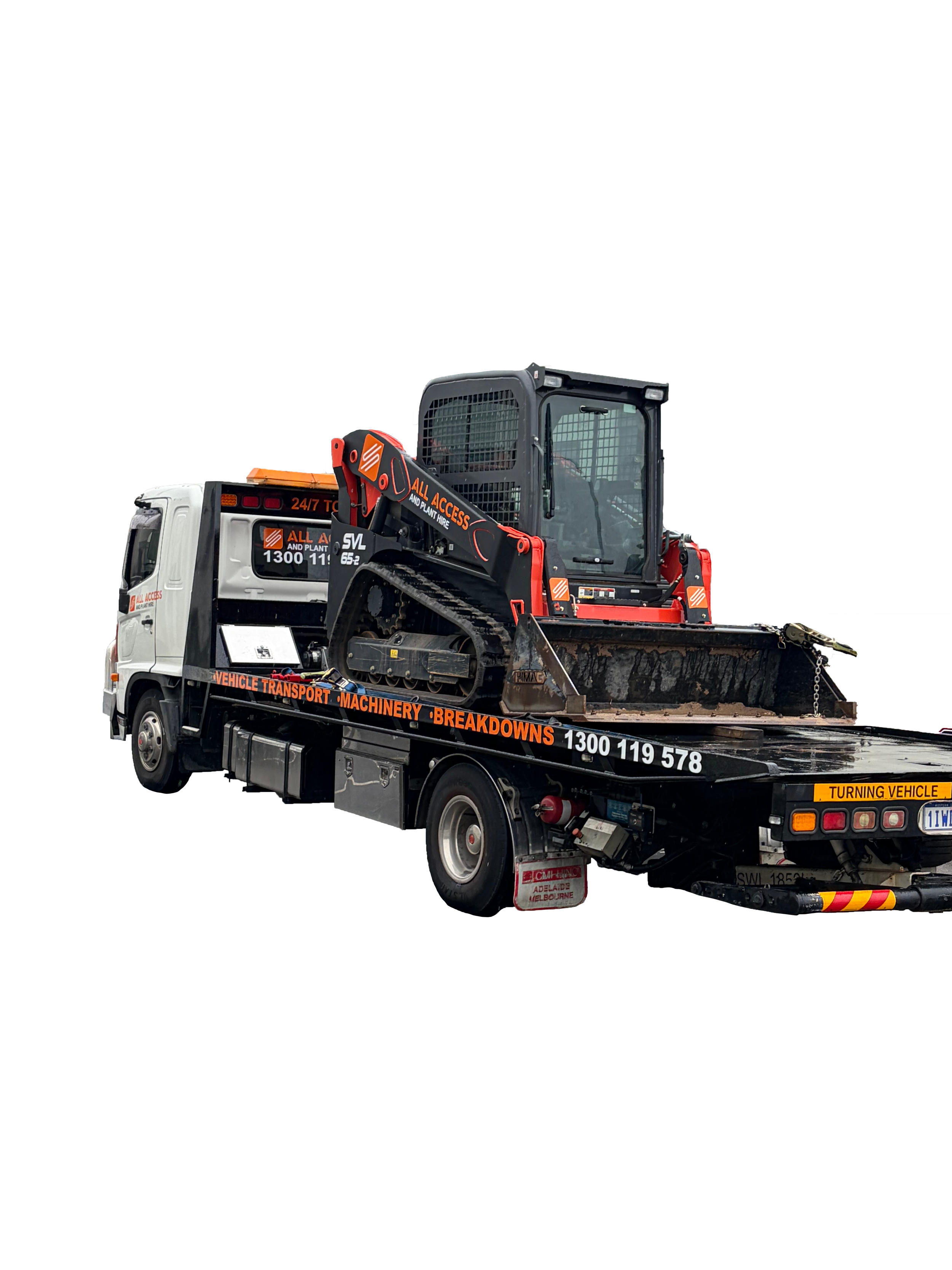 A flatbed tow truck transporting a skid steer loader with a cab and tracks. The truck is white with black and orange markings and has warning labels, including one that says "Turning Vehicle". The loader is black and orange and has the words "All Access" and "And Plant Hire" on its arm.