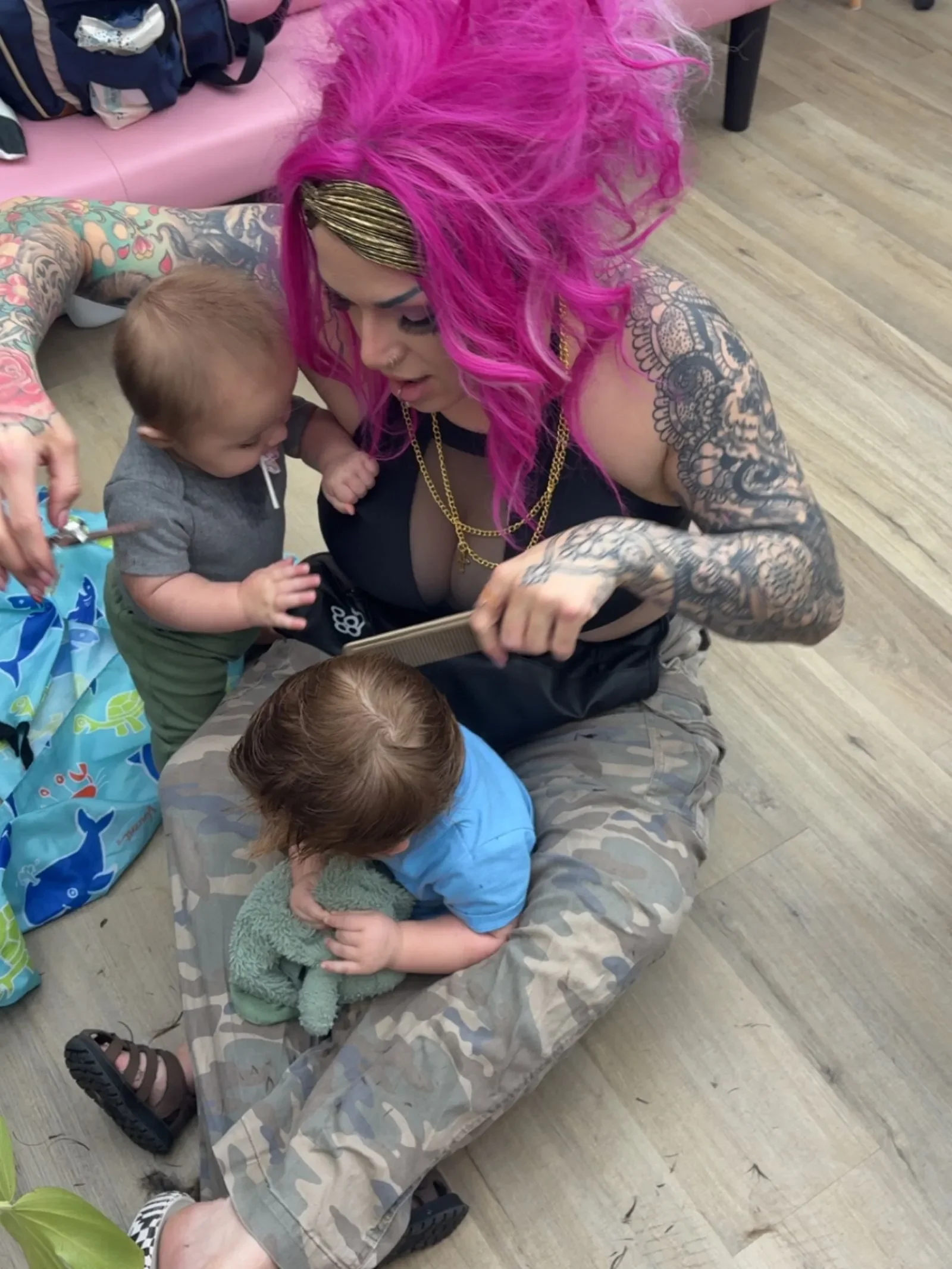 Brandi Gross cutting a toddler's hair while he sits in her lap at The Panic Room, an alternative barbershop and salon in Rapid City SD