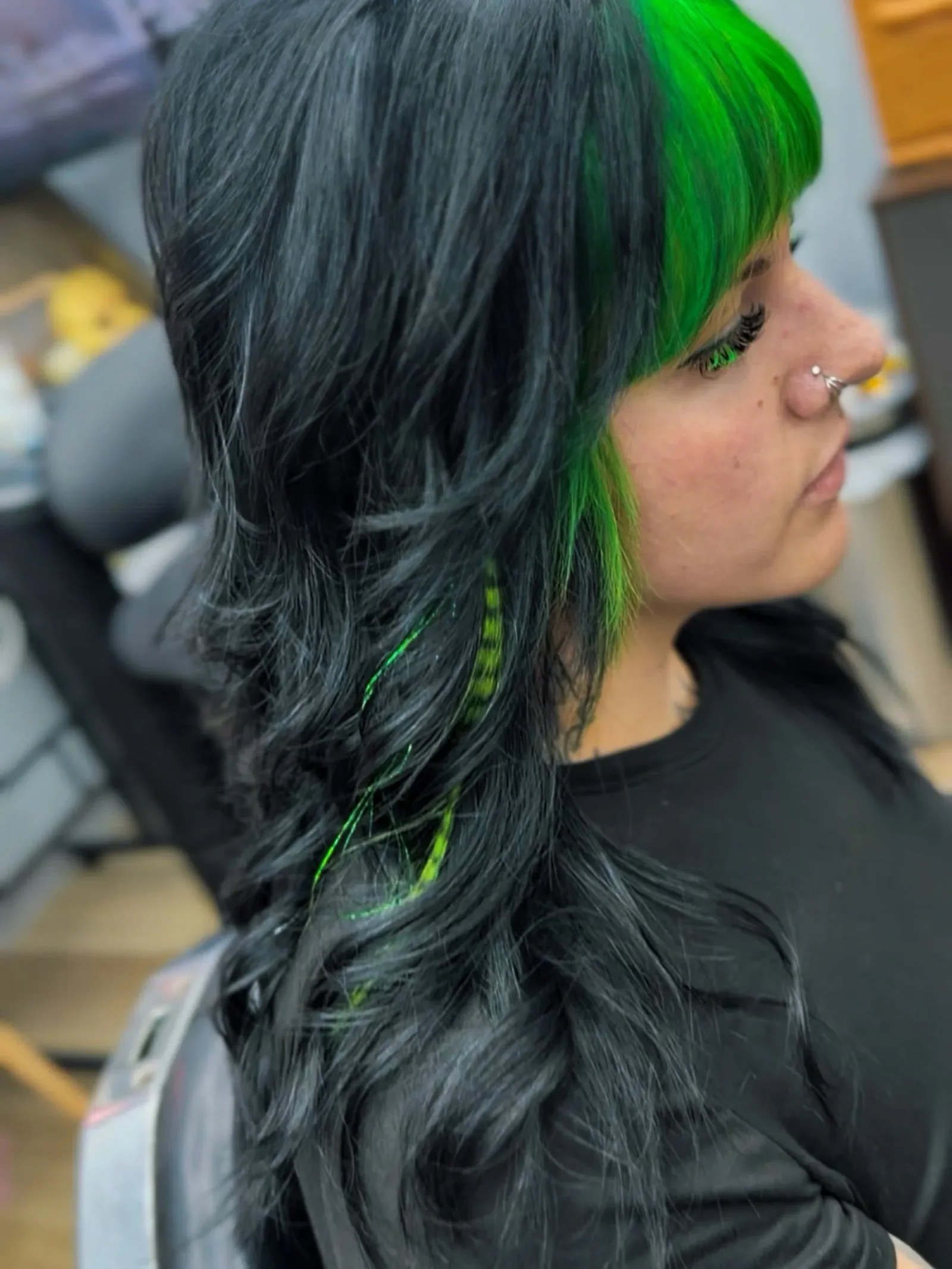 Long layered dark hair with vivid green money piece bangs and a neon green hair extension by Brandi Gross at The Panic Room in Rapid City SD.