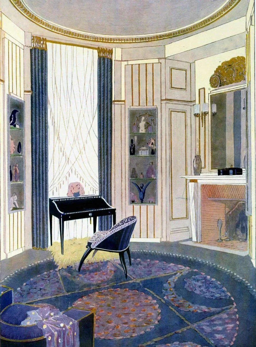 Interior of a room with blue curtains, a fireplace, a small black writing desk, a chair, and decorative items on shelves and mantle.