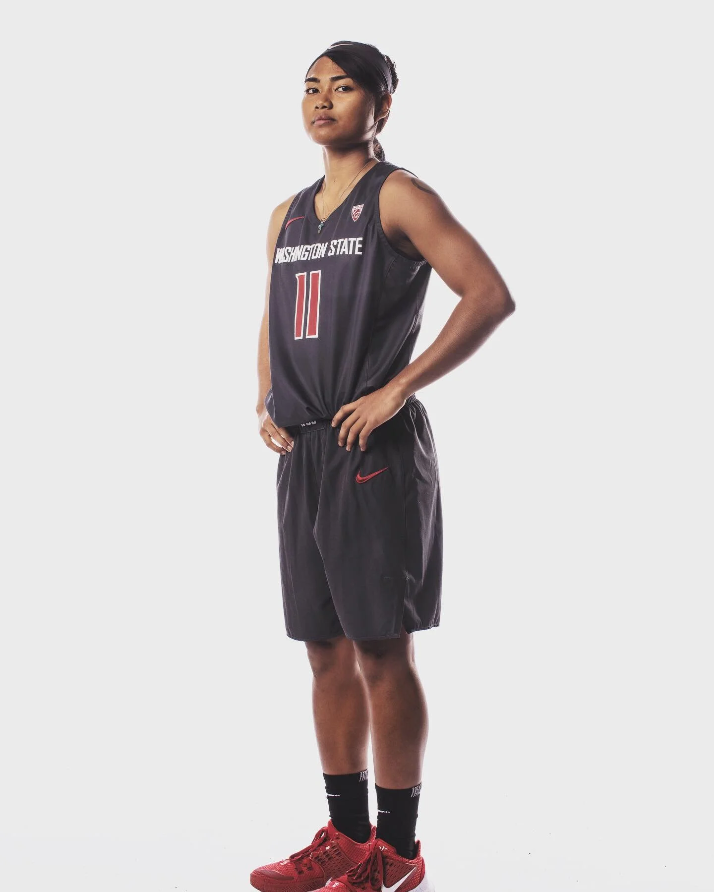 Basketball player in Washington State uniform standing with arms on hips.