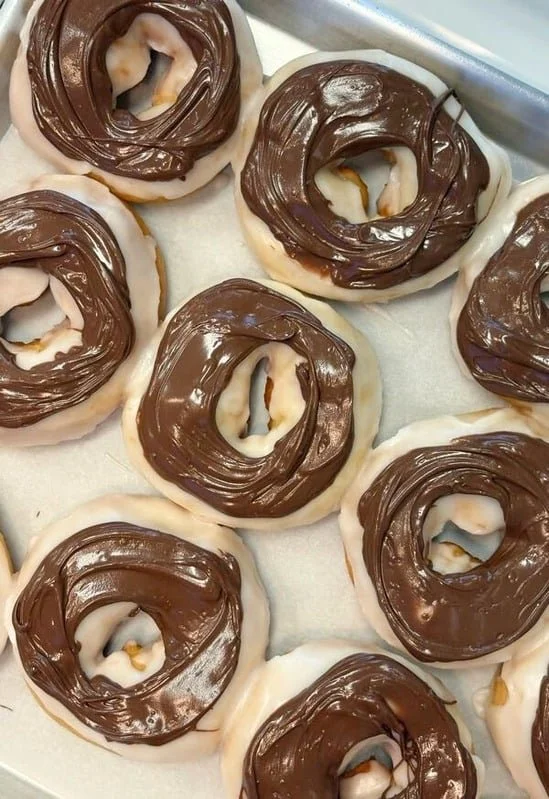 Chocolate and vanilla coated donuts arranged on a tray.