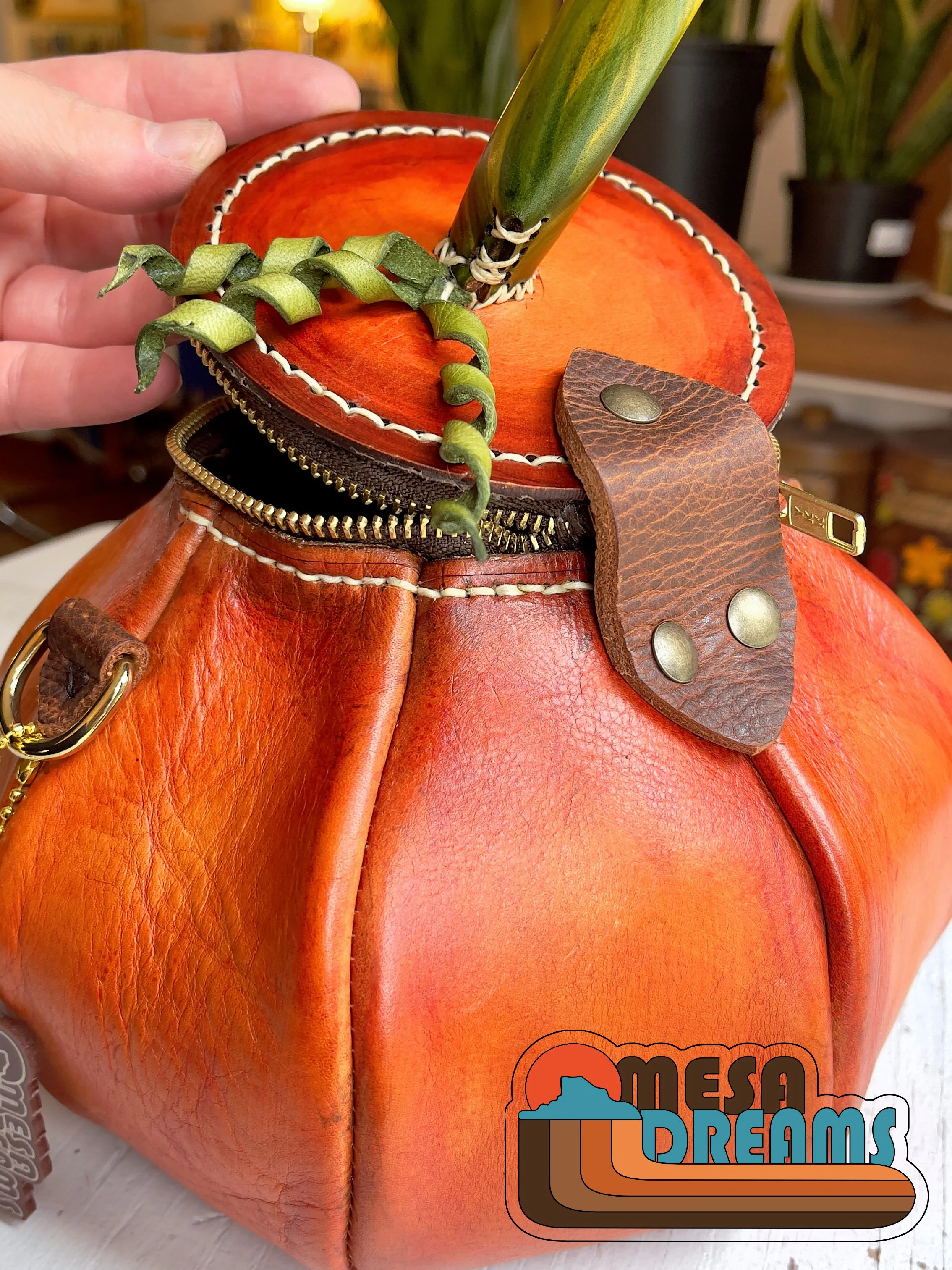 The Great Pumpkin bag shown in profile highlighting the soft brown leather hinge that connects the lid to the body of the bag.