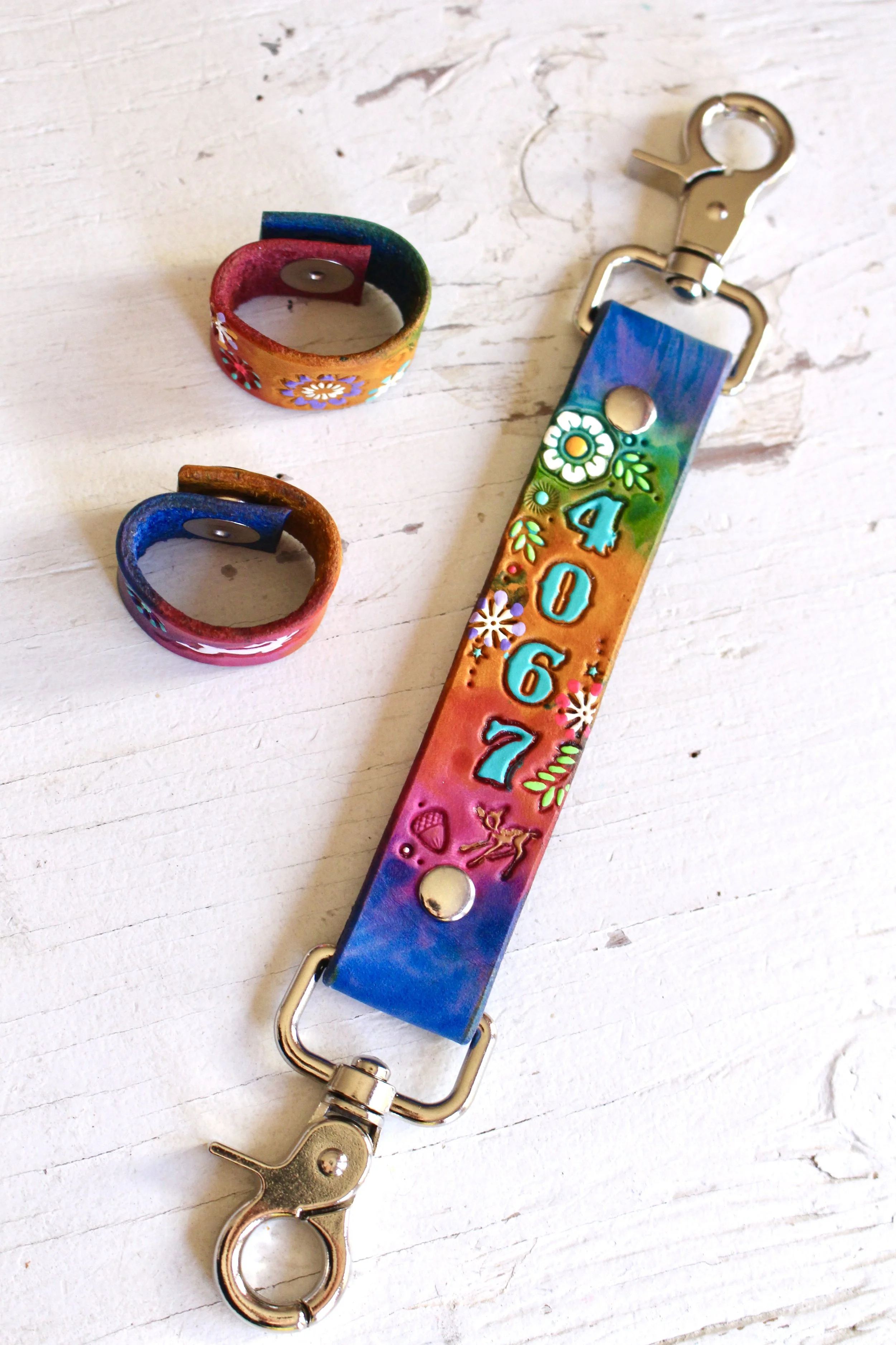 a leather anti-sway strap with very colorful leather stain colors in blue, pinks, green and yellow. It has heavy duty hardware in silver.