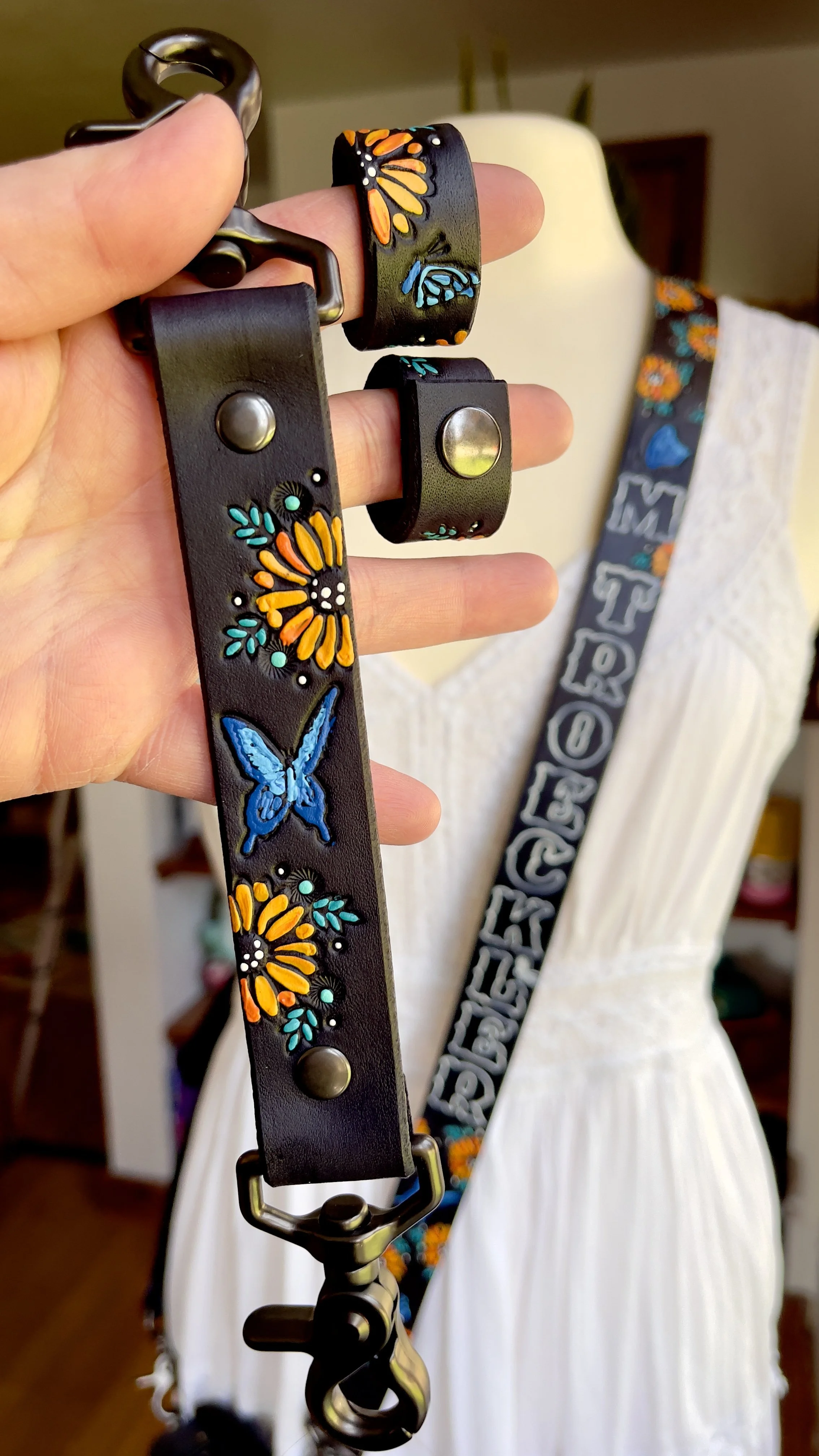 a black leather fire radio strap with sunflowers and blue butterflies tooled and stamped into the leather