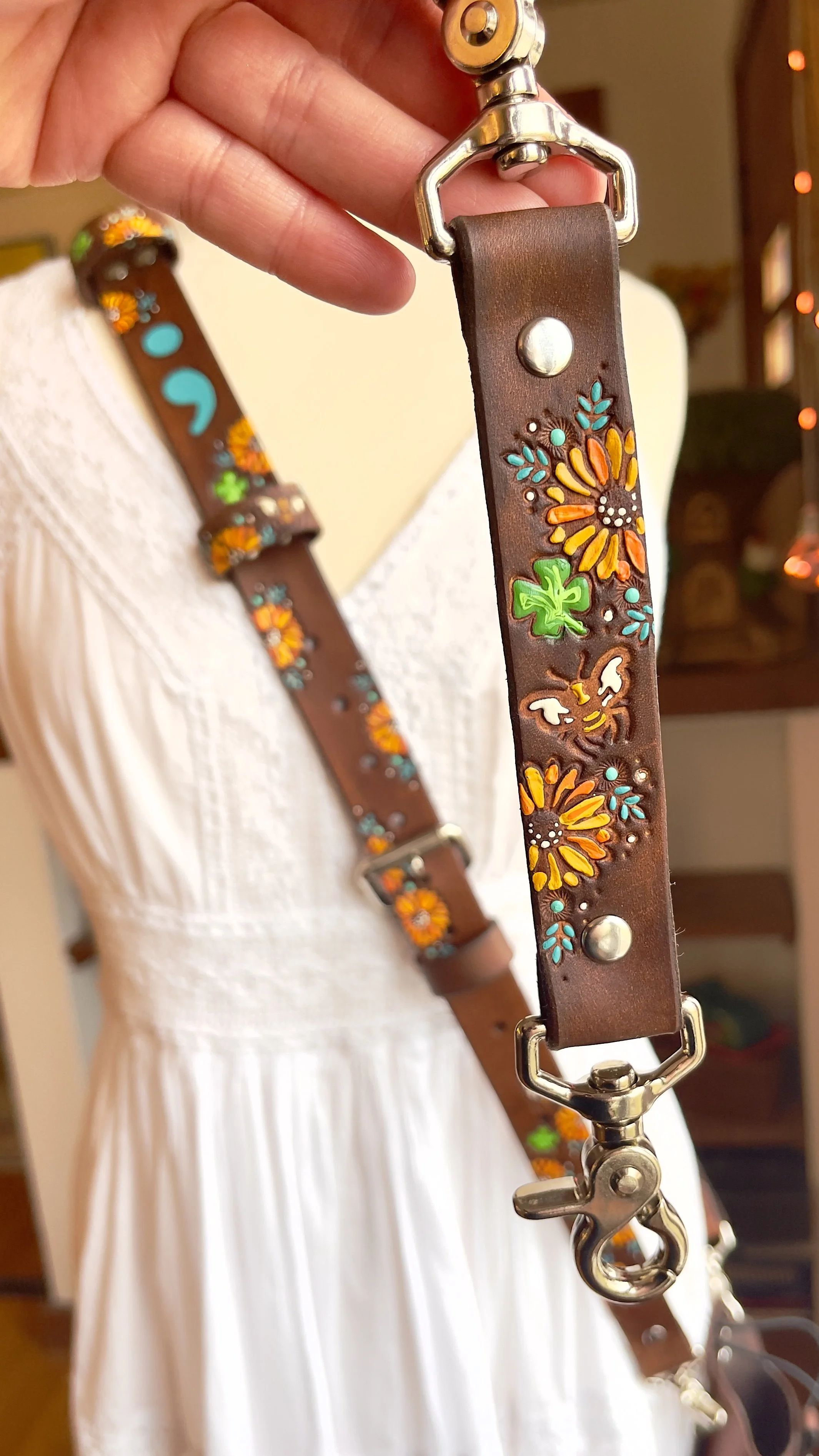 a fire radio strap set covered in green four leaf clovers, sunflowers and bumblebee stampings. It has silver hardware and clip loops.