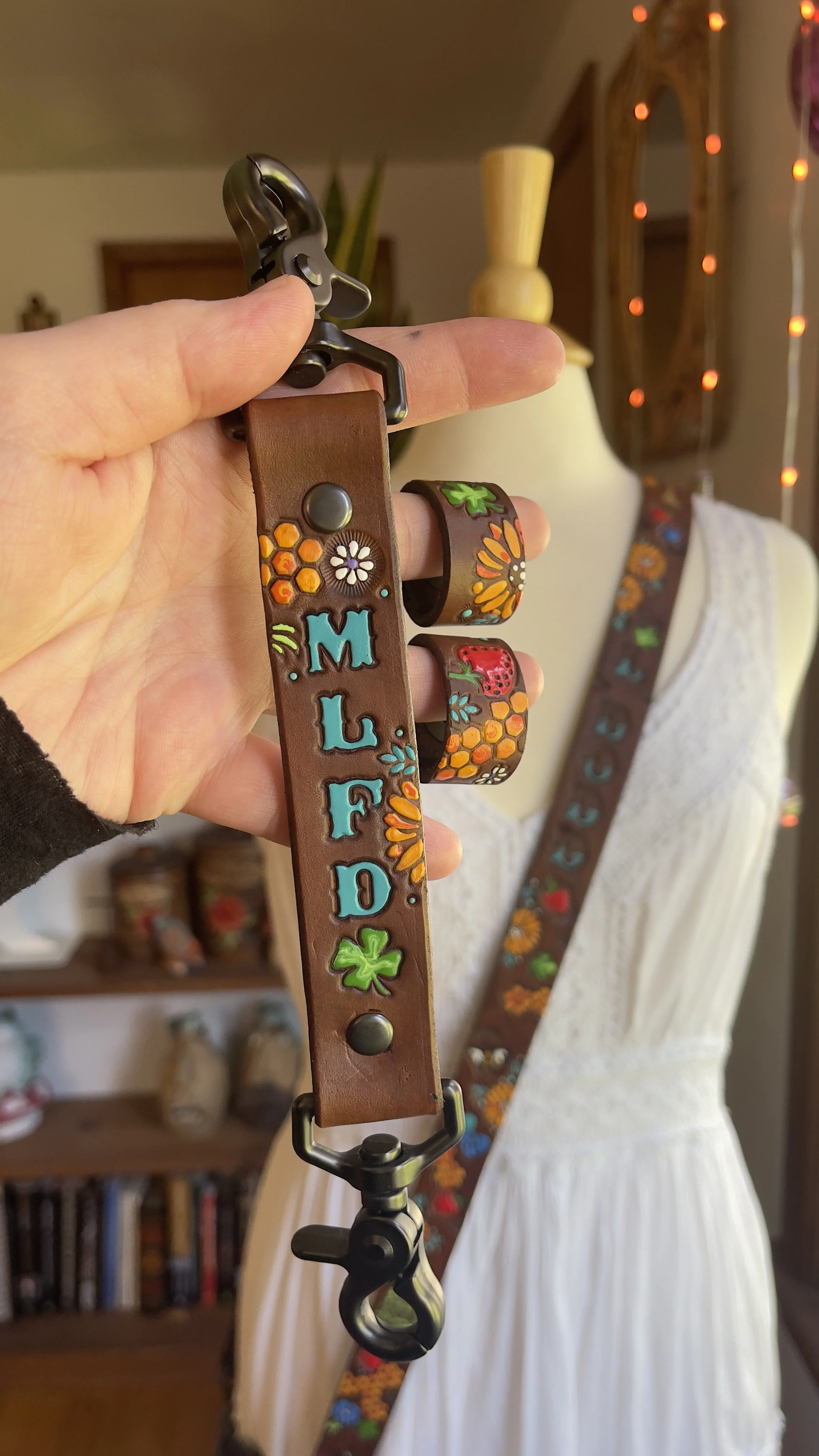 a brown leather anti-sway strap with fire department initials, flowers, clovers and honeycombs