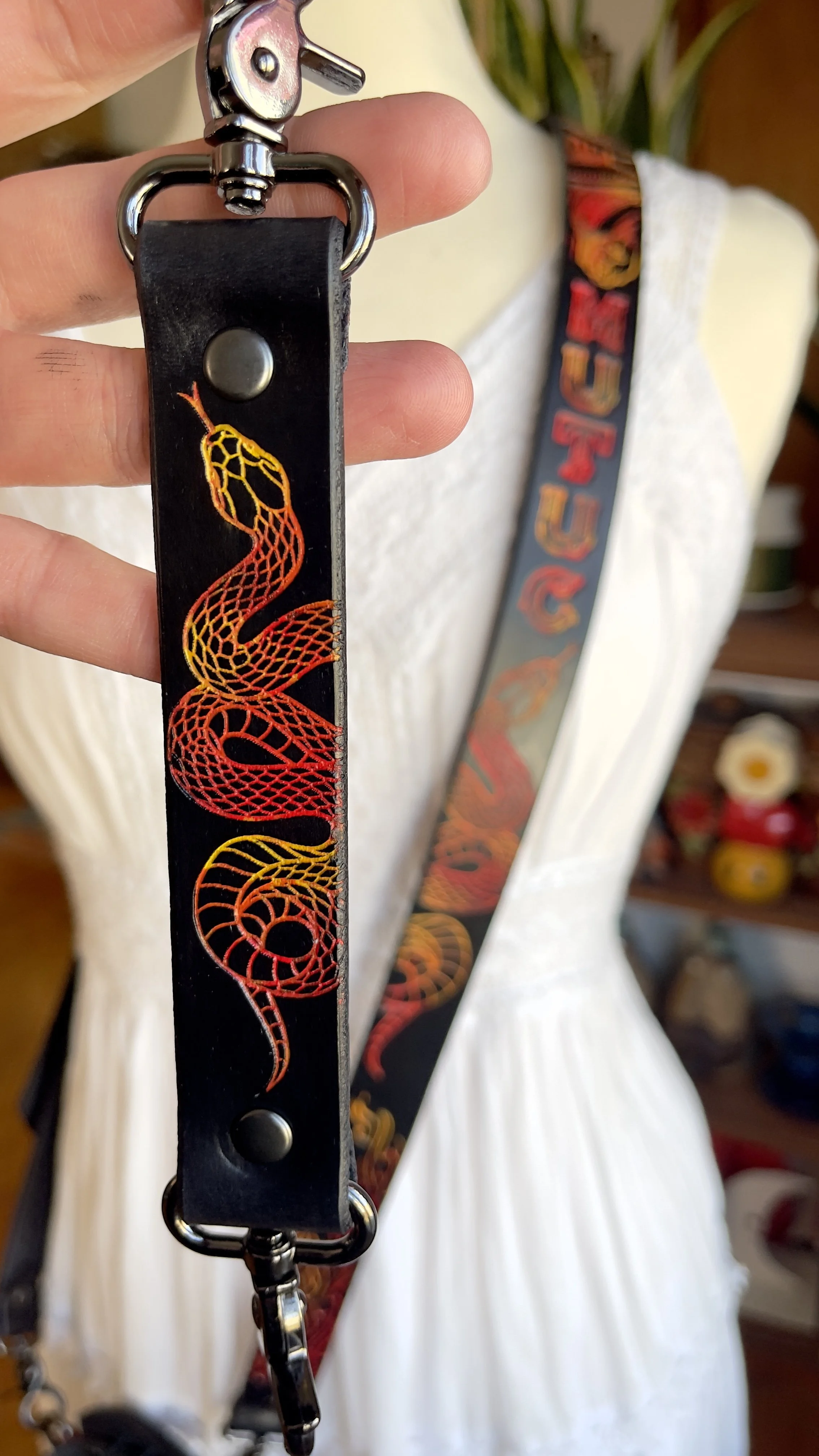 a black leather fire radio strap with engraved designs of flames, fire and snakes in bright red, yellow and orange tones