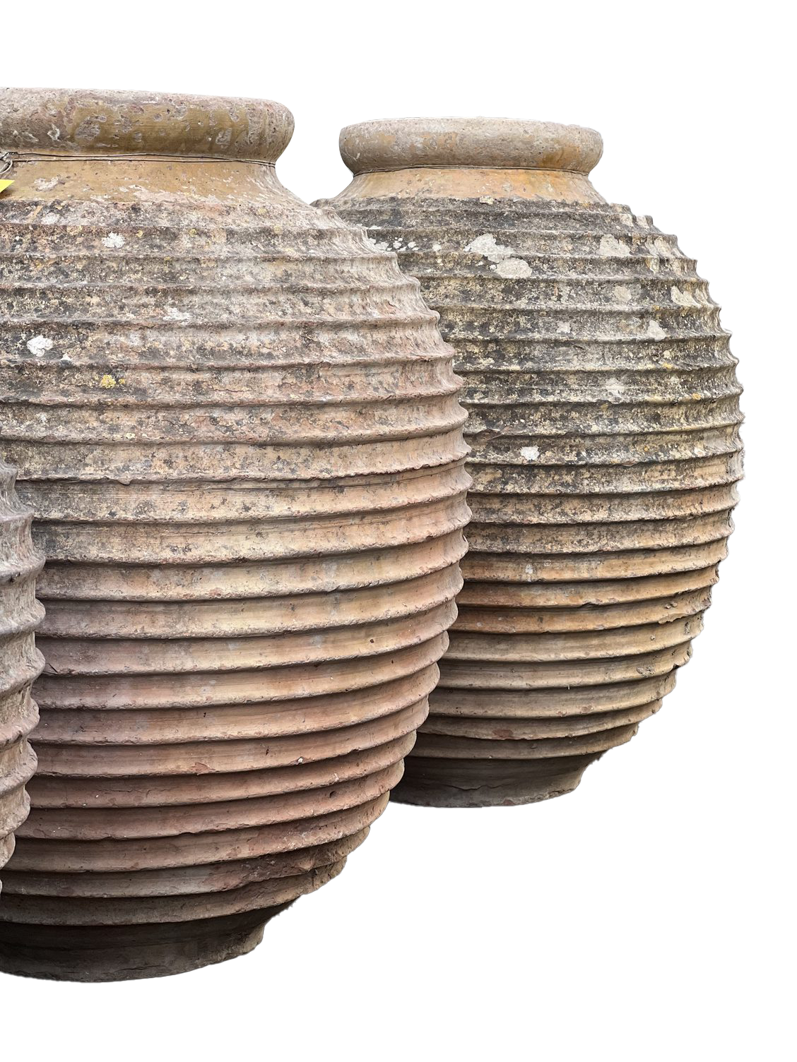Two ancient, weathered clay pots with ribbed surfaces and rounded mouths, stored outdoors.