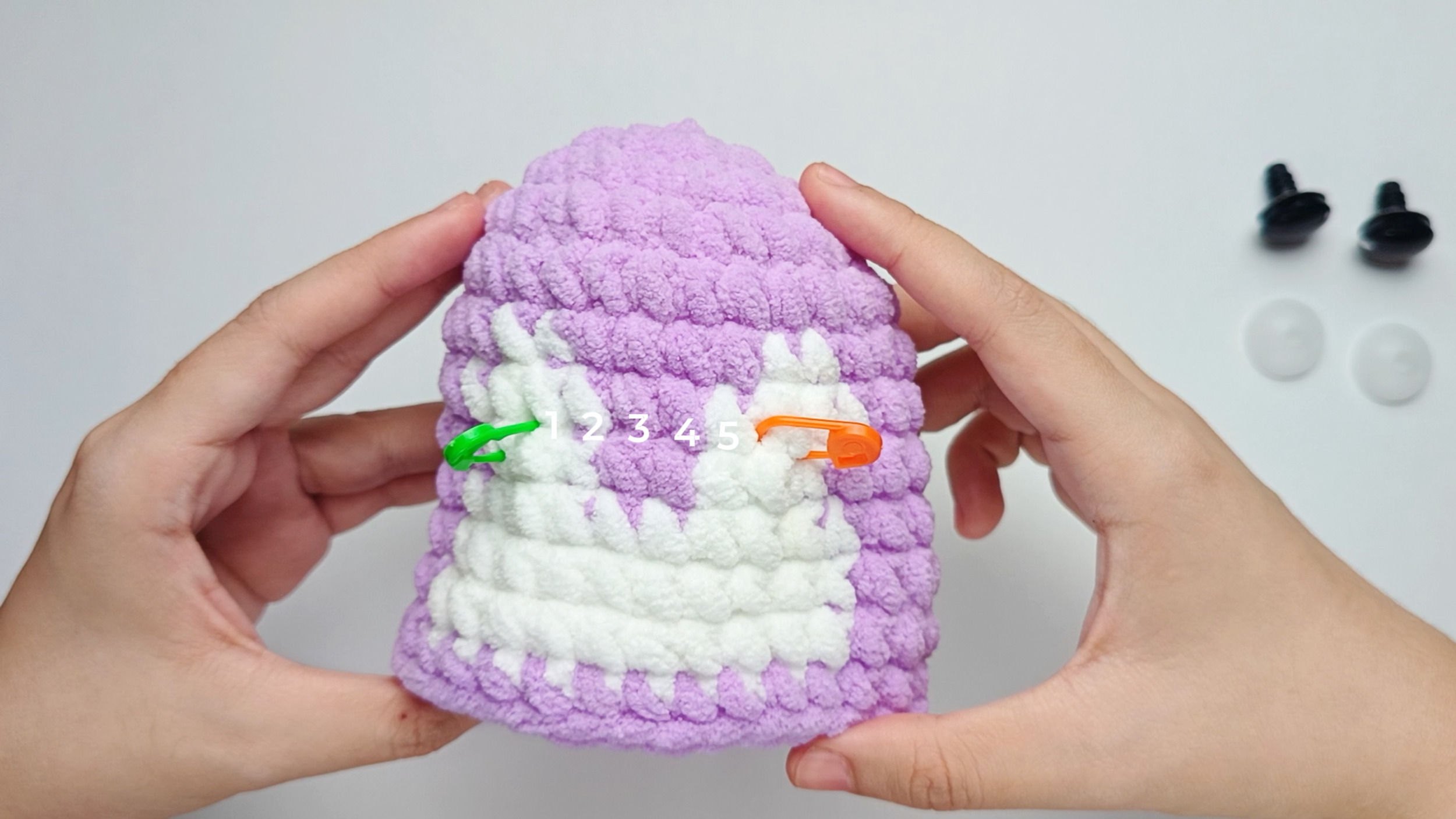 Mark before you commit: Place a stitch marker where each Eye will go, so you can still move them. Set them level with each other and about 5-6 stitches apart - one Eye on each of the two white patches at the front - so they sit evenly on the white.