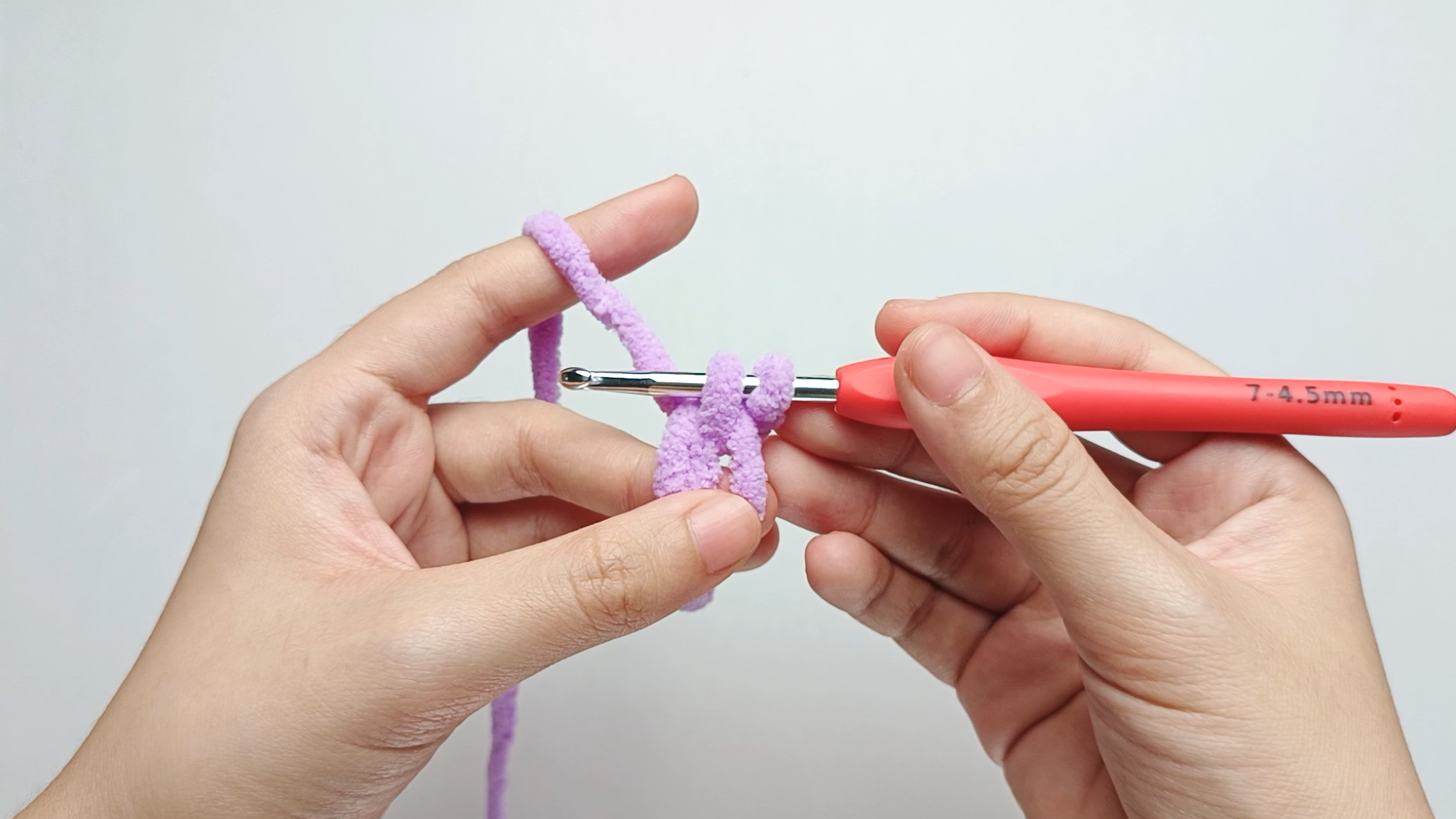 Yarn over and pull up a loop: Yarn over with the working yarn and pull it through the center of the ring, drawing up a loop. You now have two loops on your hook.