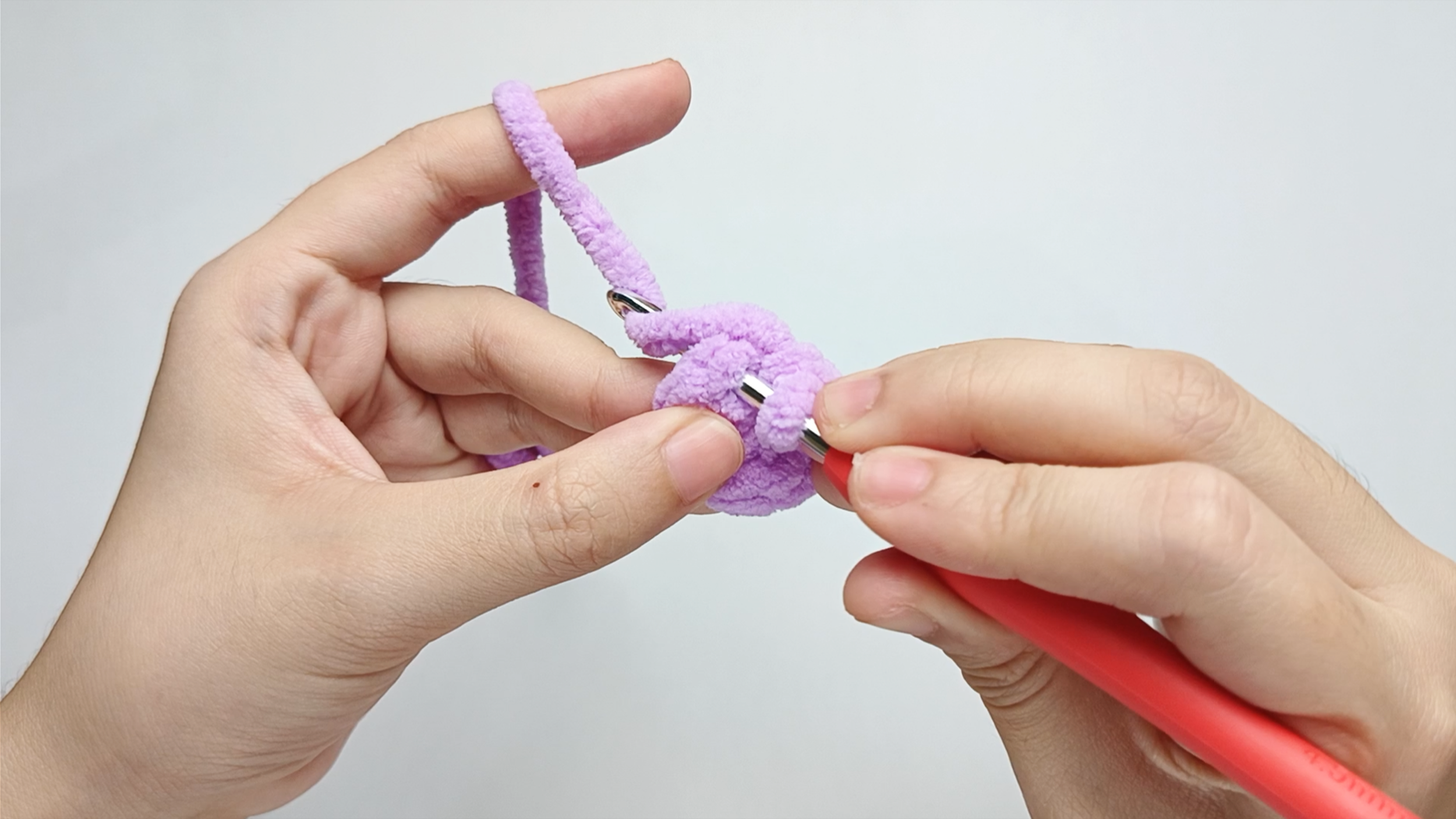 Make 1 single crochet (sc) first: Yarn over by bringing your hook down, behind the working yarn, and up again so the yarn wraps around it.