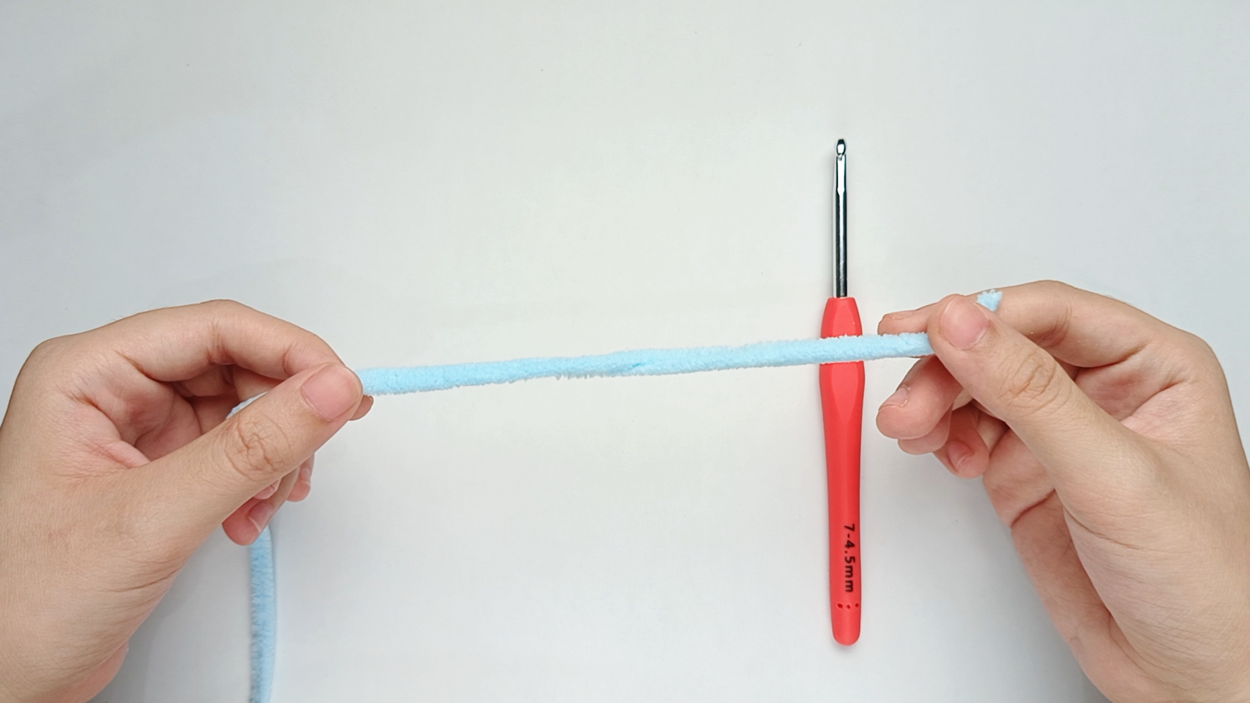 Hold your yarn: Start with holding the yarn tail in one hand and the working yarn (the strand leading to the ball) in the other.