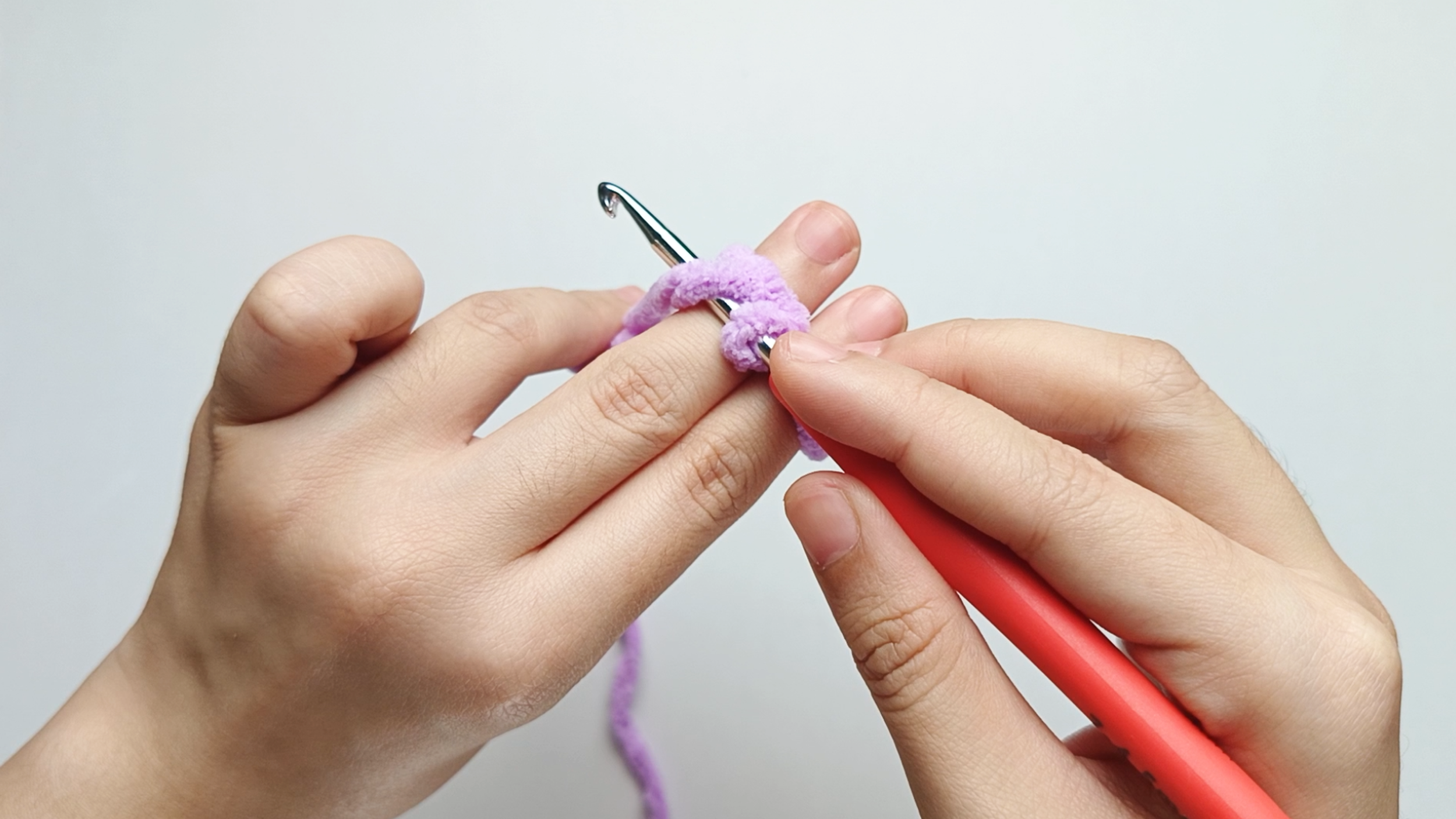 Yarn over: Bring your hook down, behind the working yarn, and up again so the yarn wraps around it.