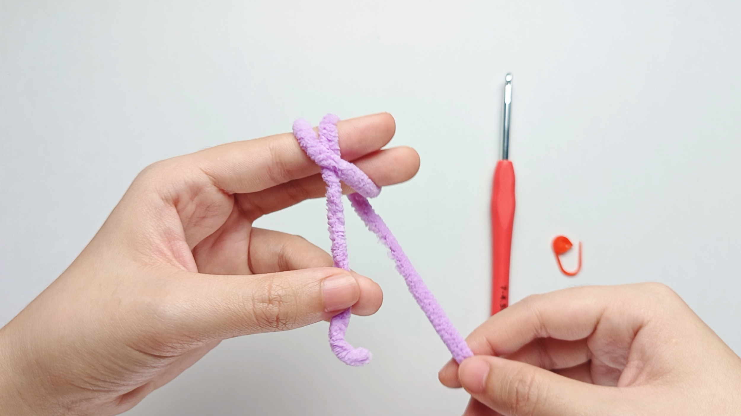 Wrap around again: Continue wrapping the yarn around your index and middle fingers, then bring it back toward your palm.